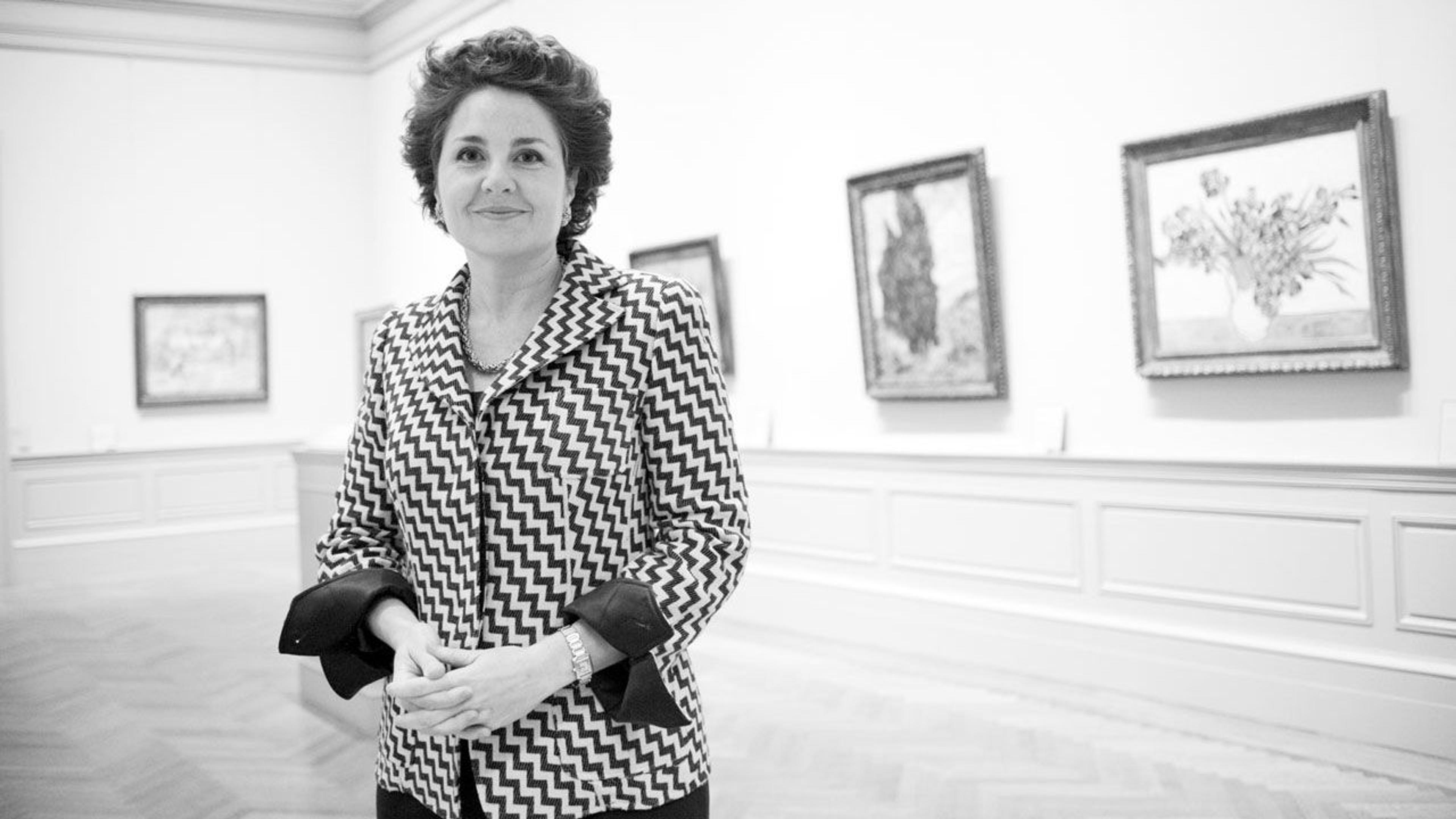 Black and white photograph of curator Rebecca Rabinow standing in a paintings gallery at The Met