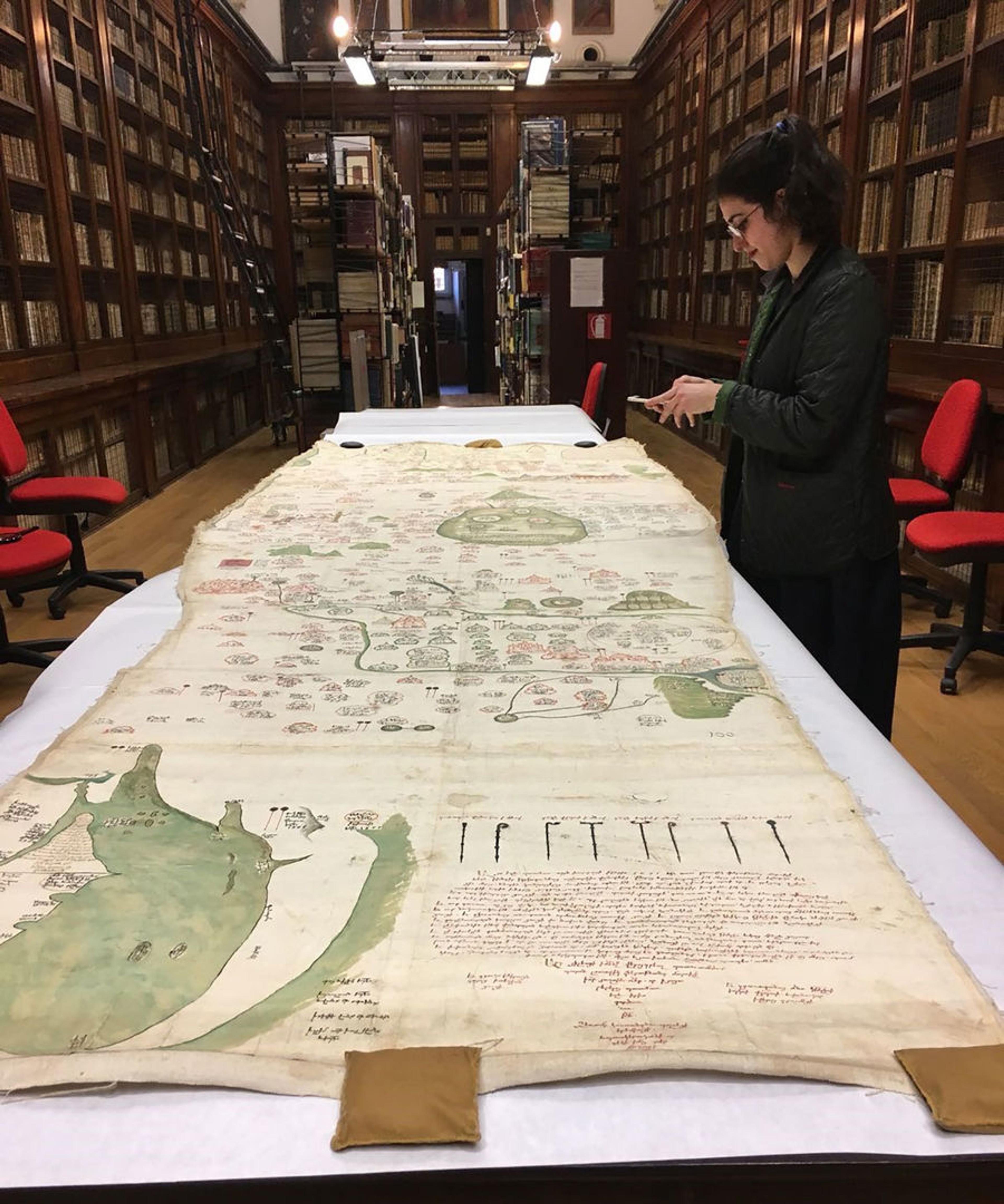 The author looking at the map spread out on a long table