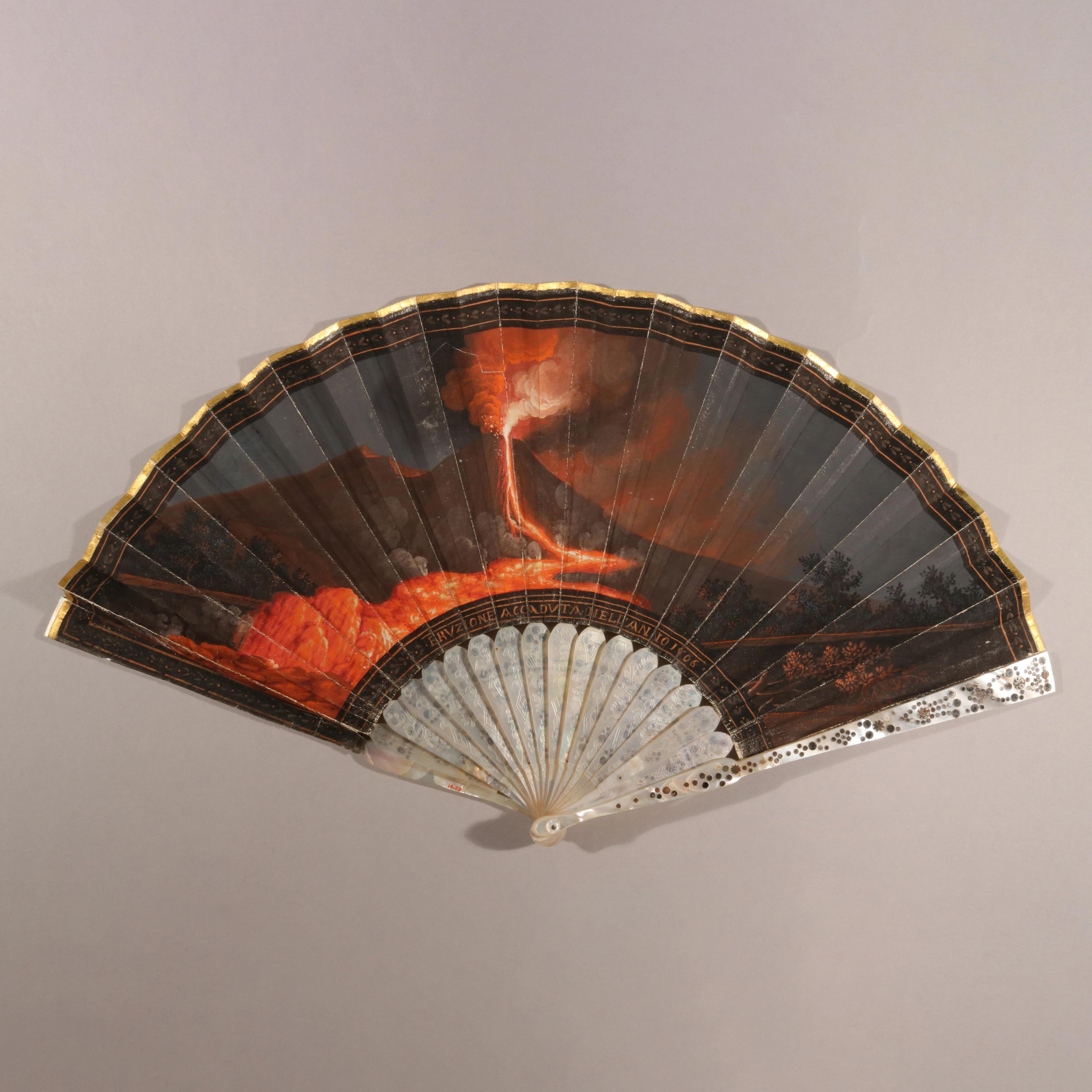 Fan showing a dramatic scene of a volcanic eruption and lava flow.