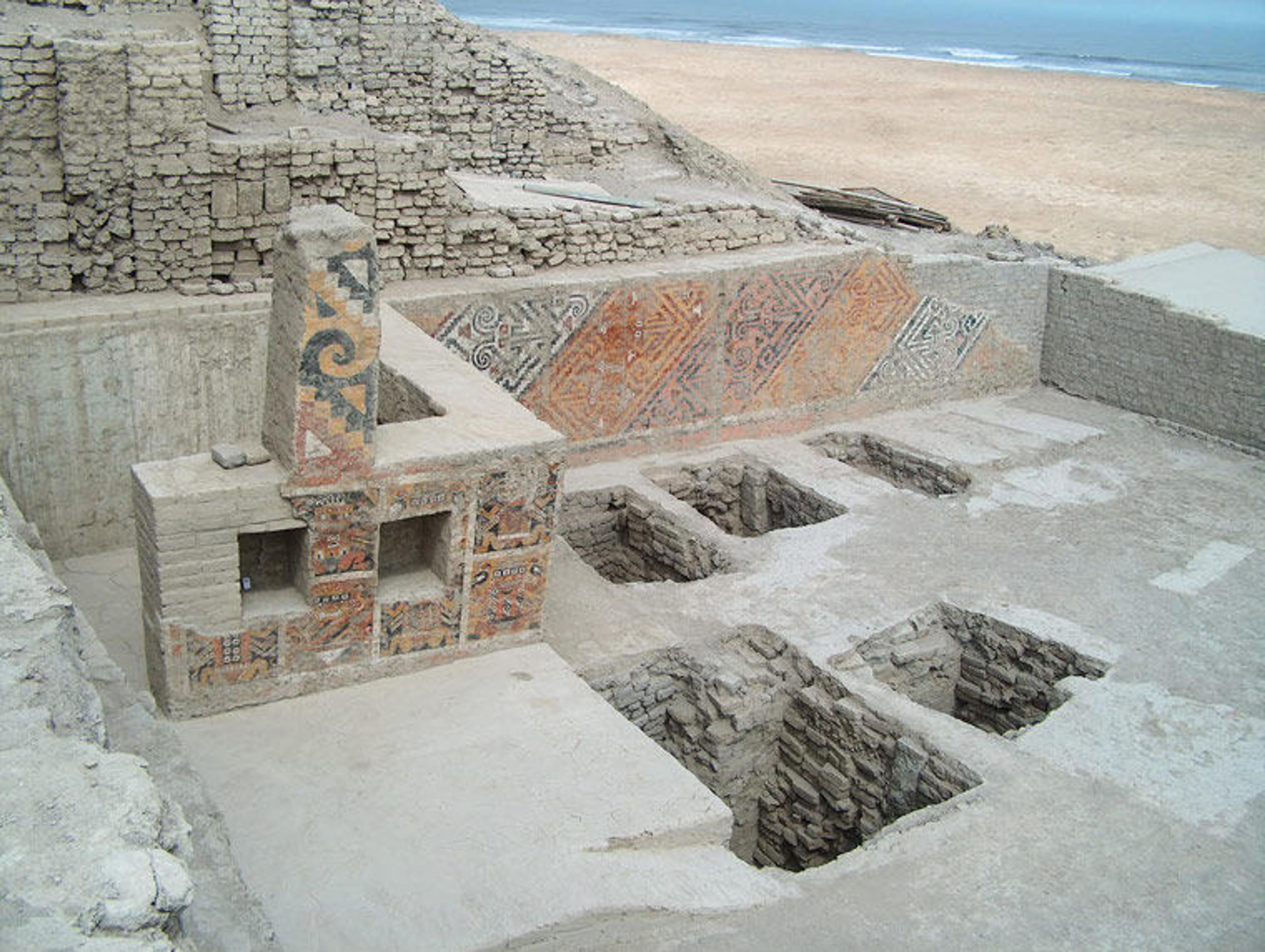 View of an excavation site in northern Peru, showing numerous tombs along the sandy coastline
