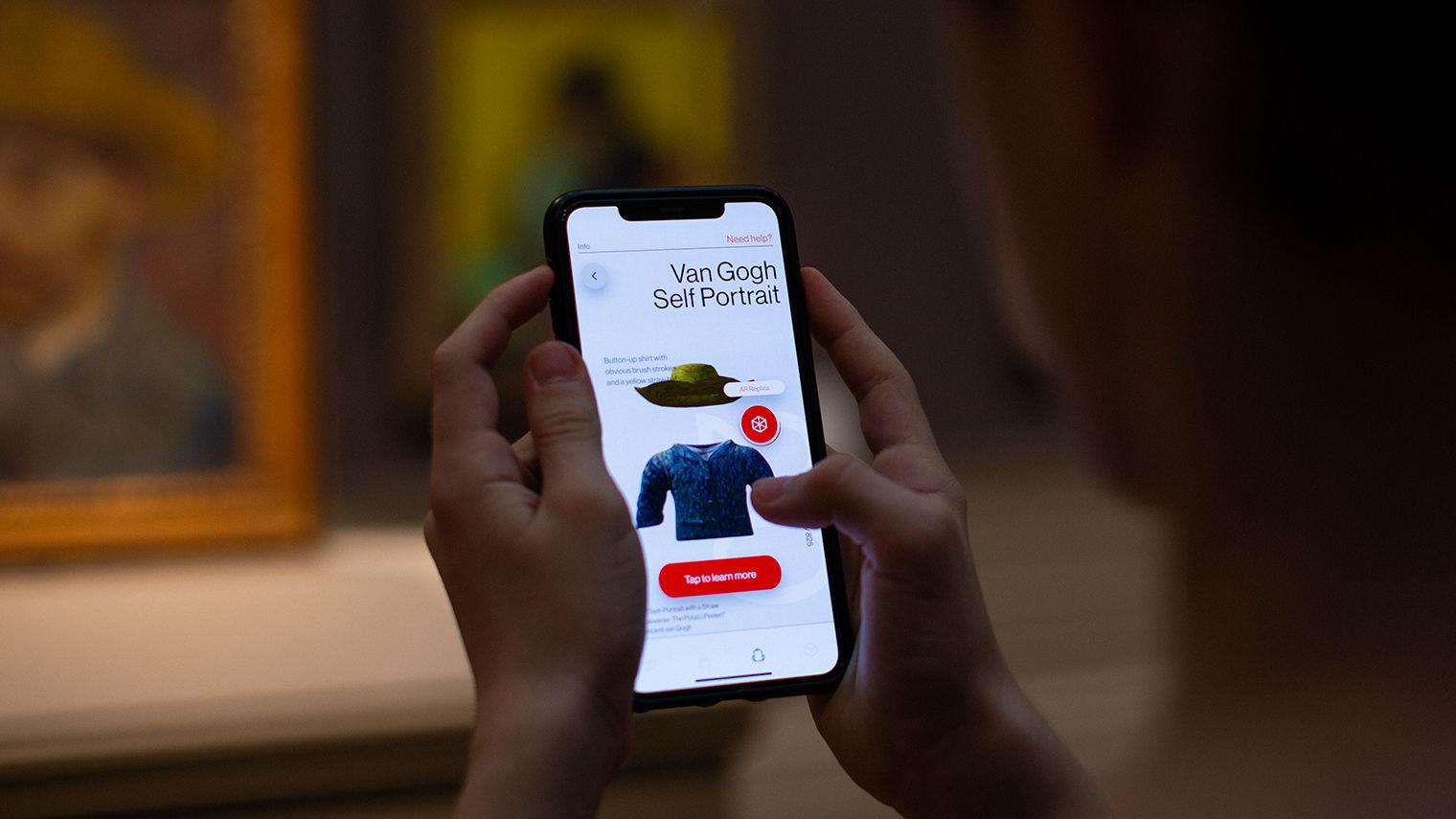 A pair of hands holding a phone with information about Van Gogh's Self Portrait on screen