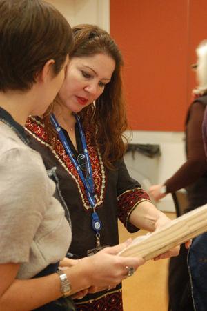 Instructor Nazanin Hedayat Munroe discusses silk painting techniques with a student.