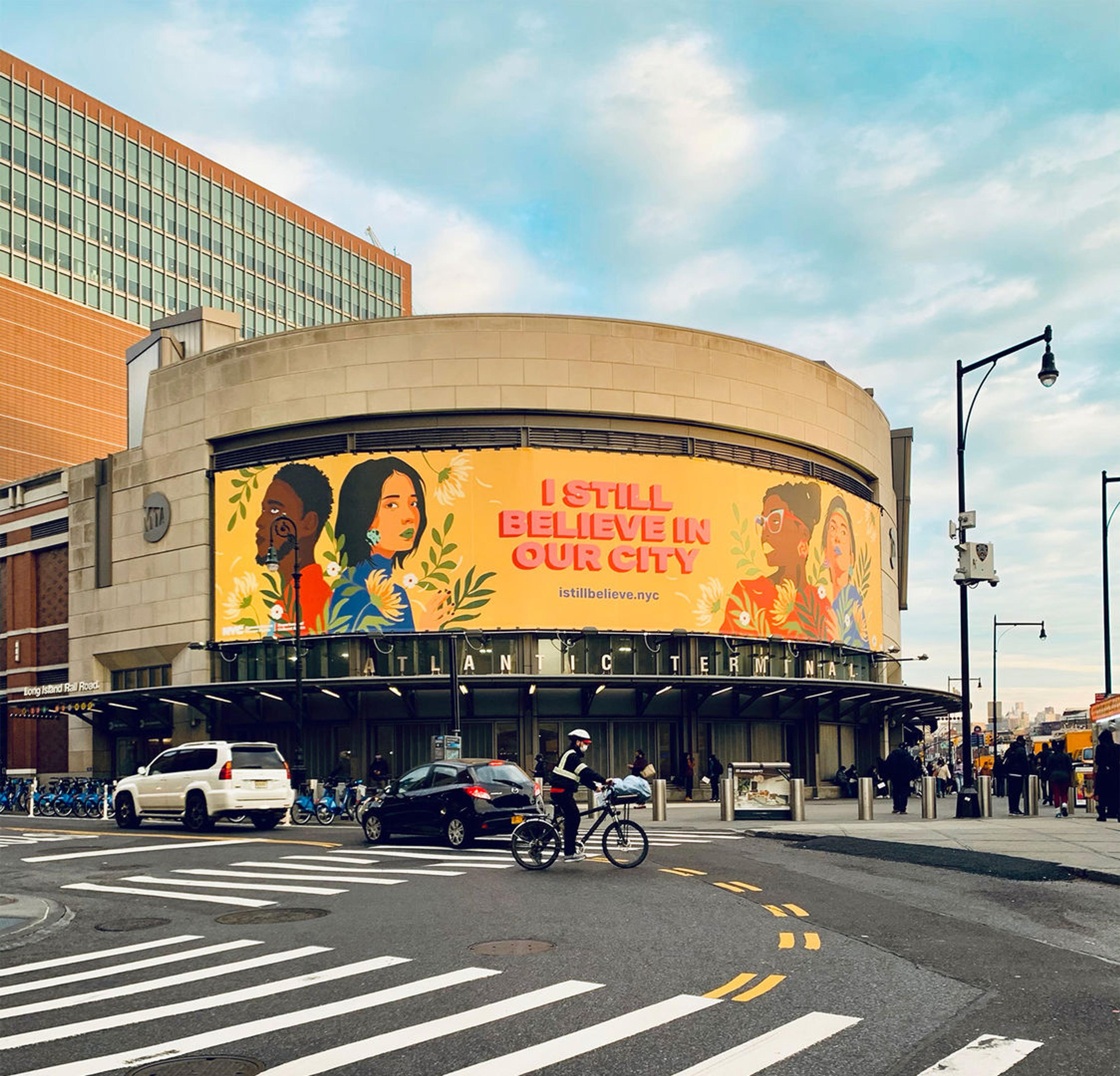 Mural with illustrations of people of color with the text "I Still Believe in Our City."