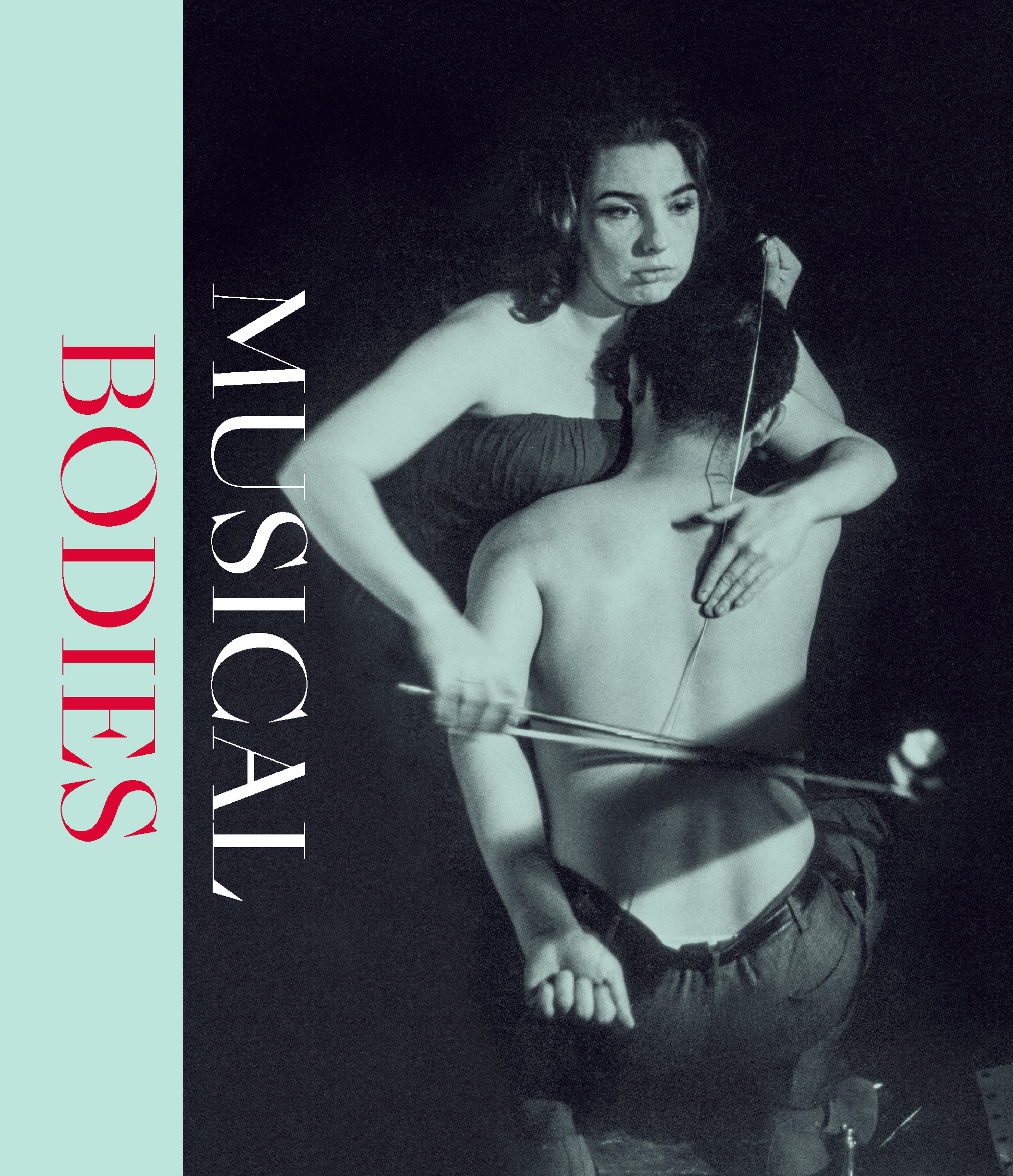 a black-and-white photograph of a woman playing a music bow on a string suspended against a man's bare back