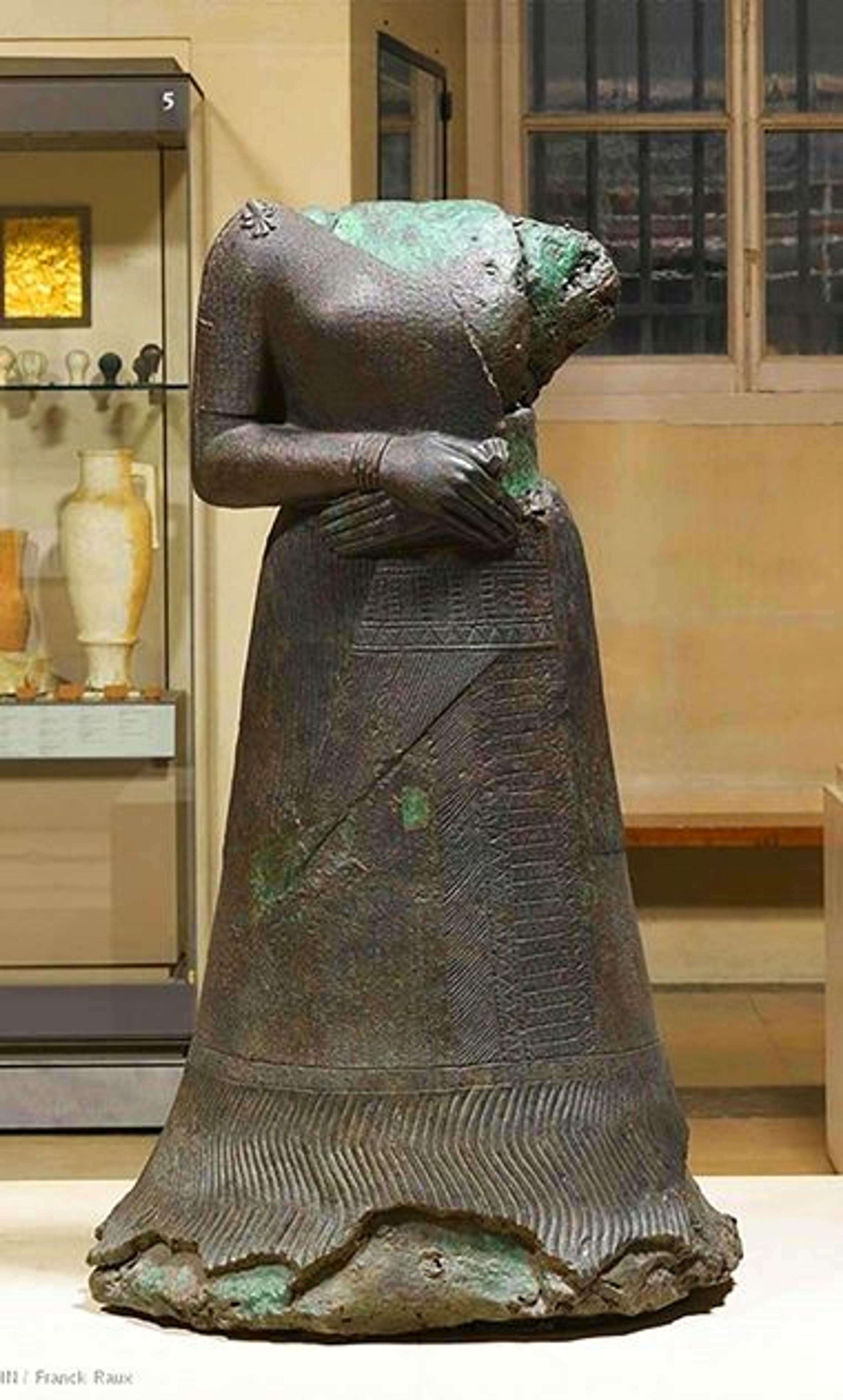 The headless statue of a woman with her arms crossed and a long skirt