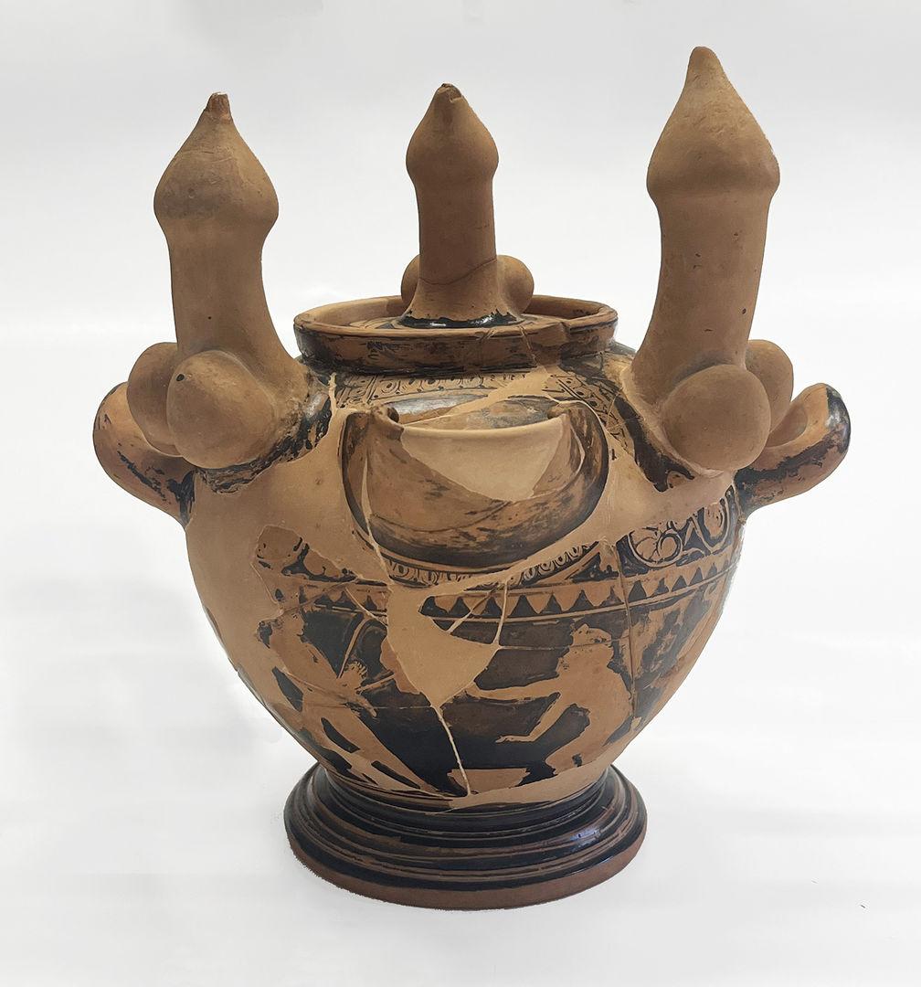Vase in shades of brown with erotic scenes around the bowl. Three sculpted erect phalluses adorn the top.