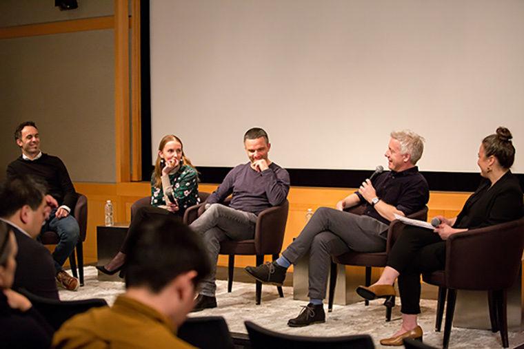 A group of panelists in a large auditorium
