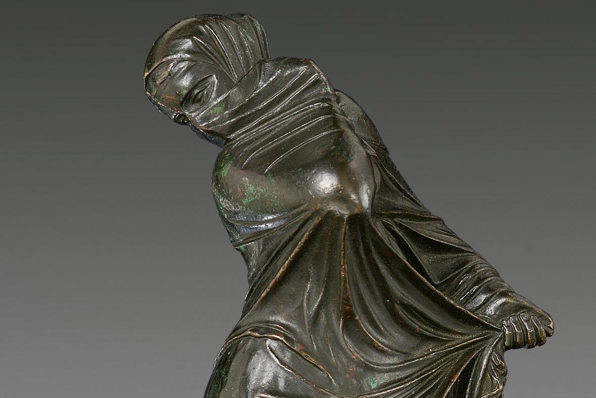 Bronze statuette of a veiled and masked female dancer.