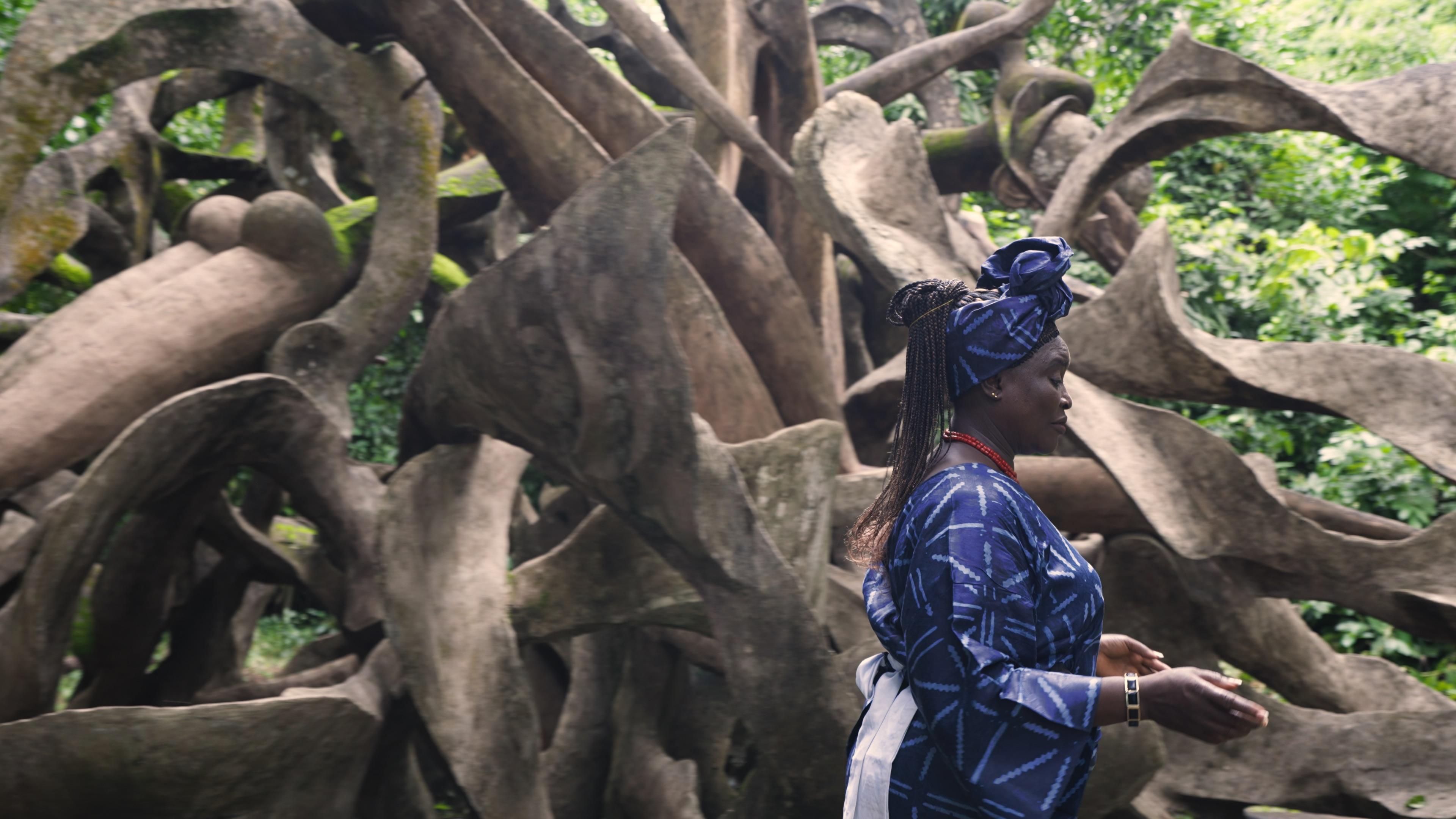 Woman walking in front of sculpture