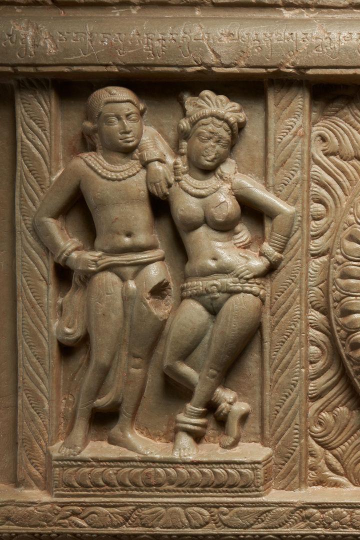 Limestone carving of a male and female figure