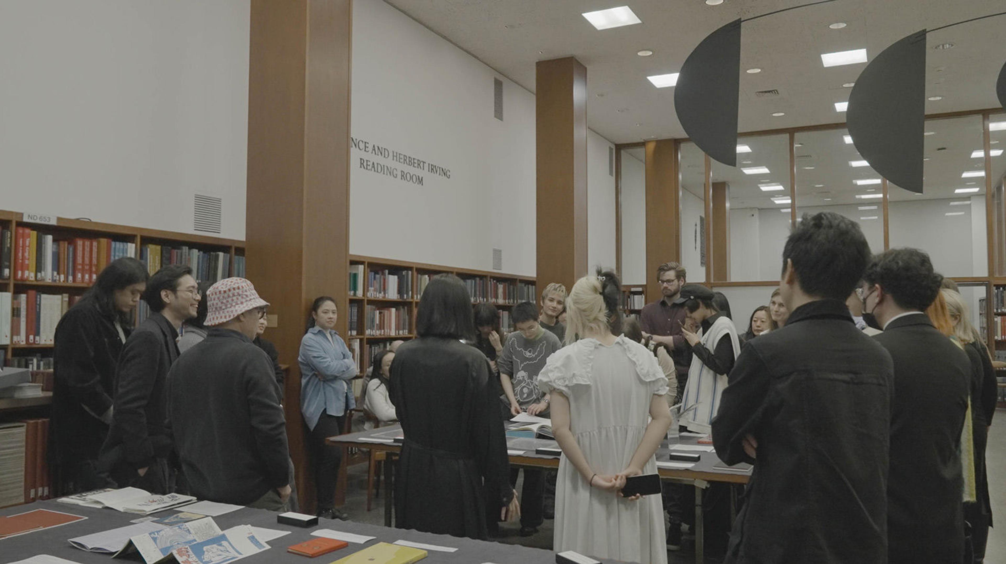 Crowd around a table looking at books