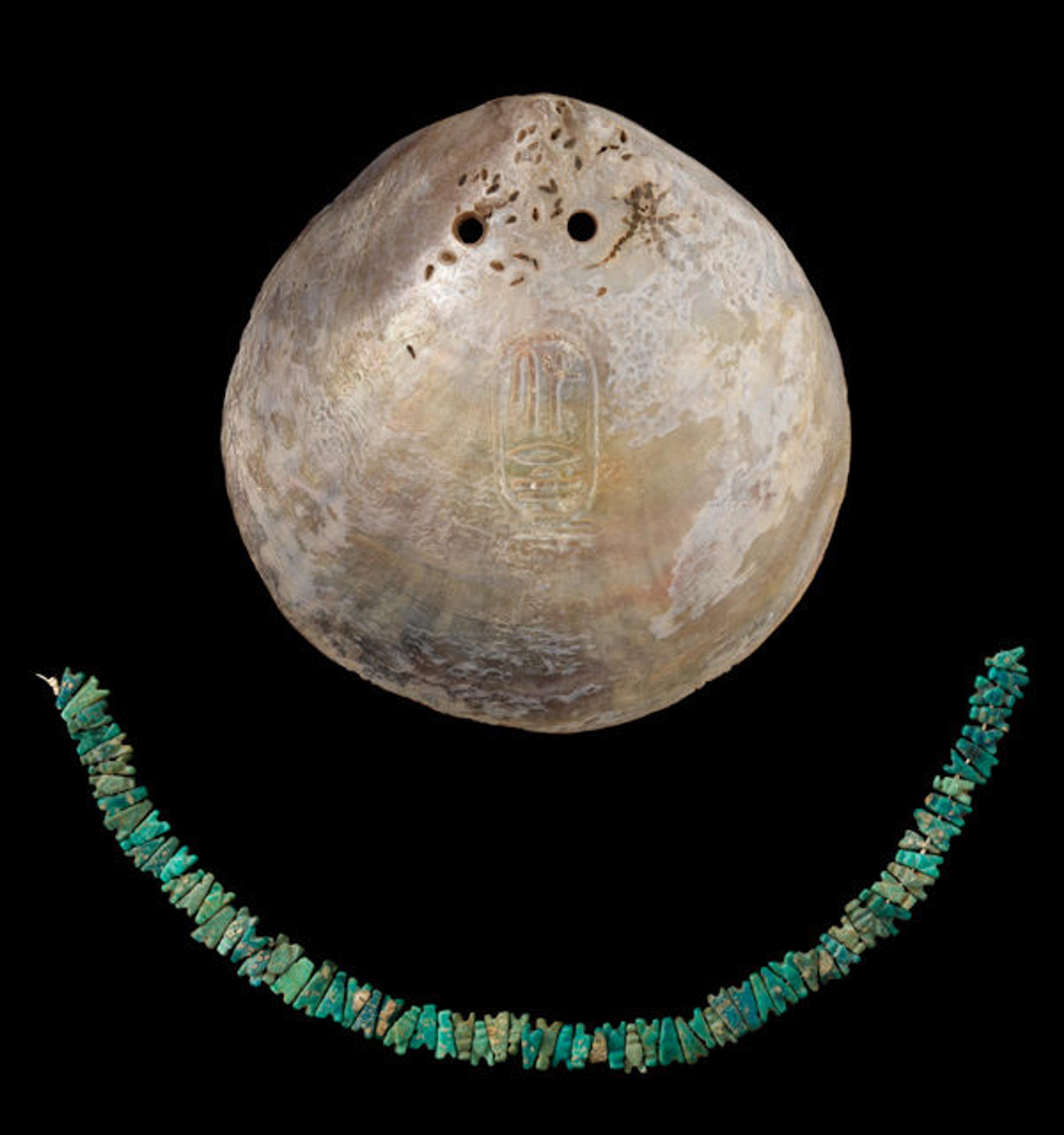 Fig. 5. Pectoral and fly-shaped beads. Middle Kingdom, Dynasty 12, probably reign of Senwosret I (ca. 1981–1802 B.C.). Deir-Rifa, Egypt. Oyster shell, faience; shell: 3 3/4 x 3 11/16 in. (9.5 x 9.3 cm); string of beads: 7 1/2 in. (19 cm); each bead: 1/4 in. (0.7 cm). The Manchester Museum, The University of Manchester (4207)
