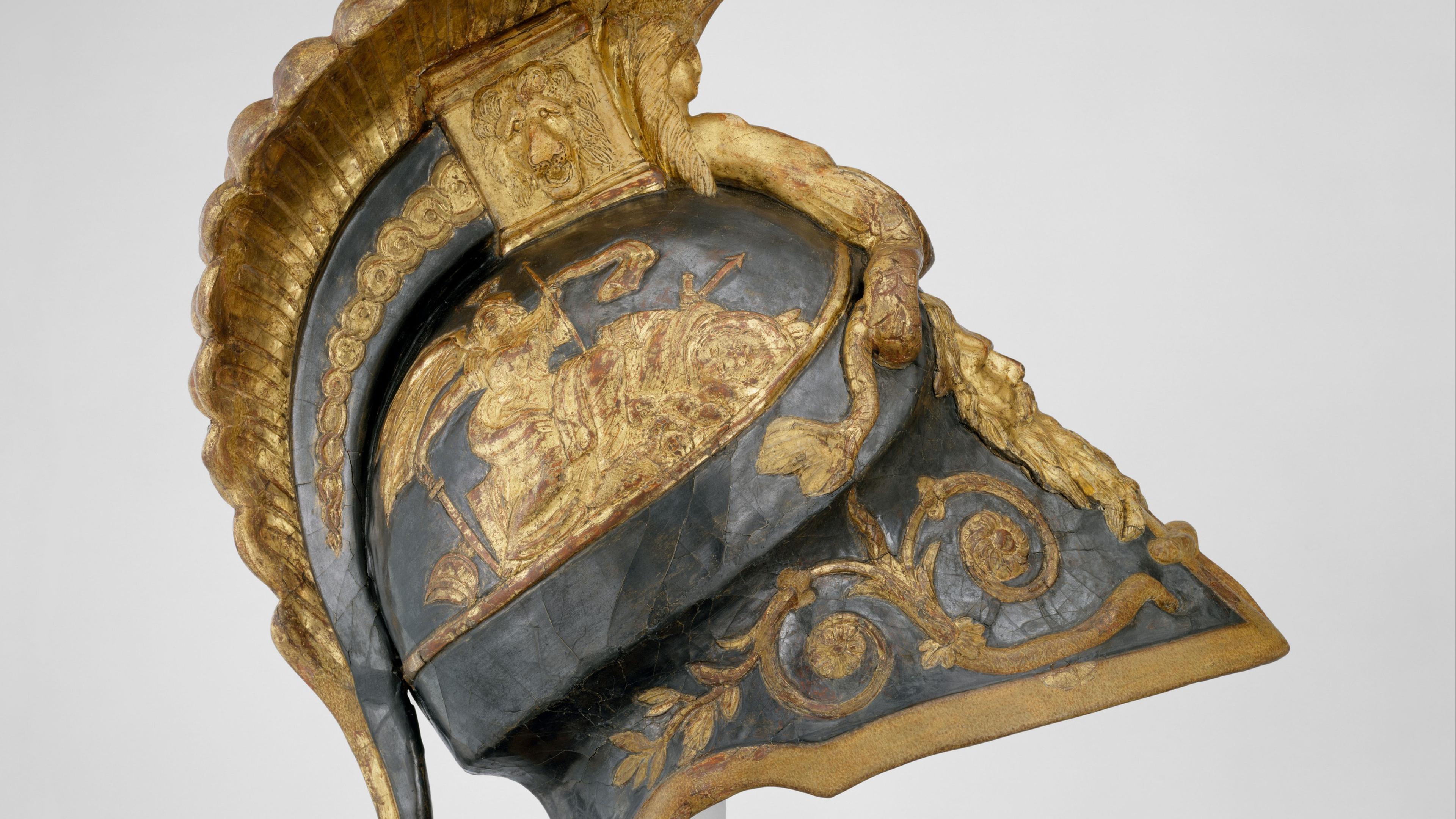 A historical costume resembling ancient Roman armor, consisting of a decorative helmet with a golden crest and ornate detailing, and a detailed tunic with embroidered patterns and imagery of lions.
