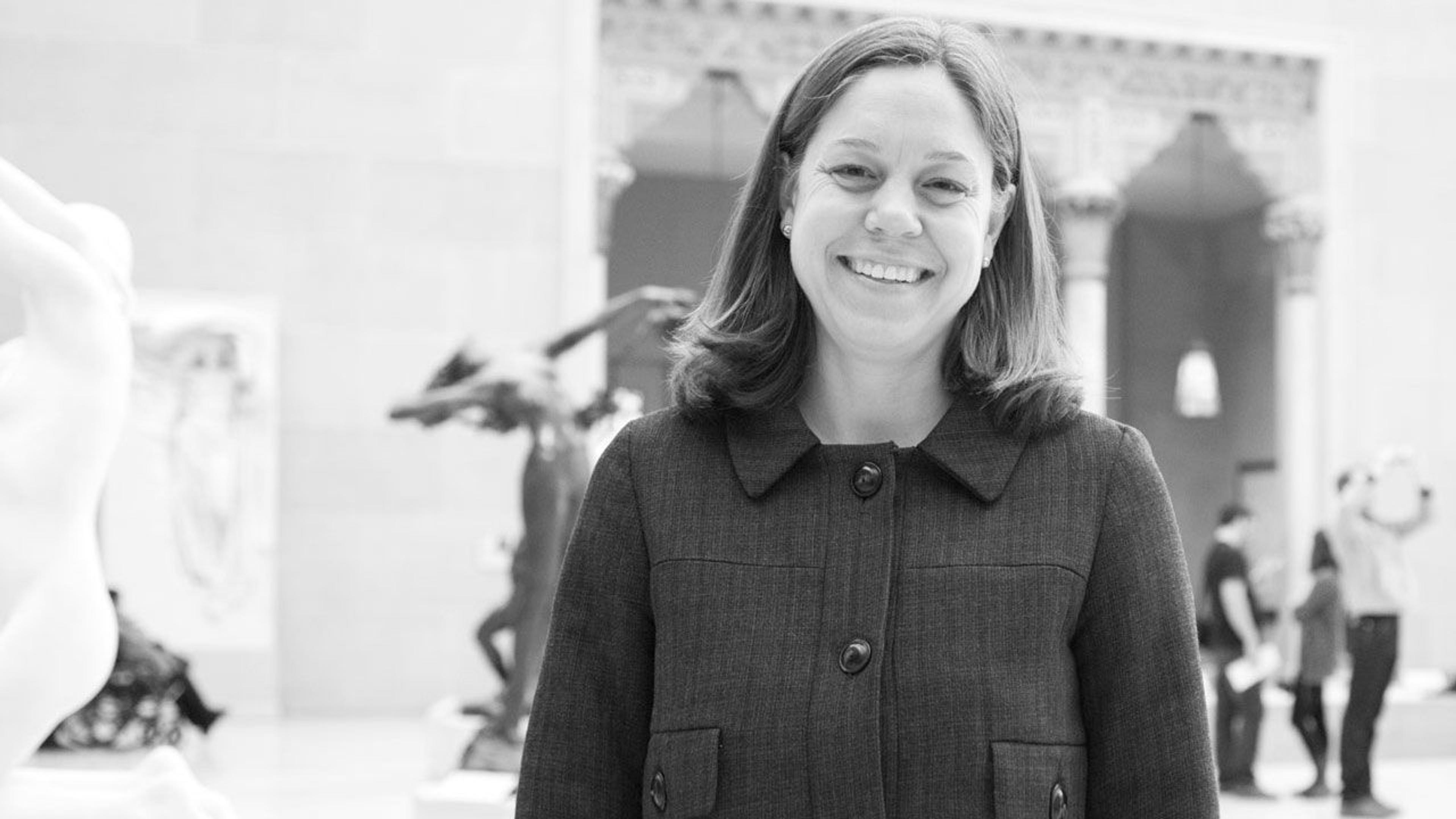 Black and white photograph of curator Thayer Tolles standing in a gallery at The Met
