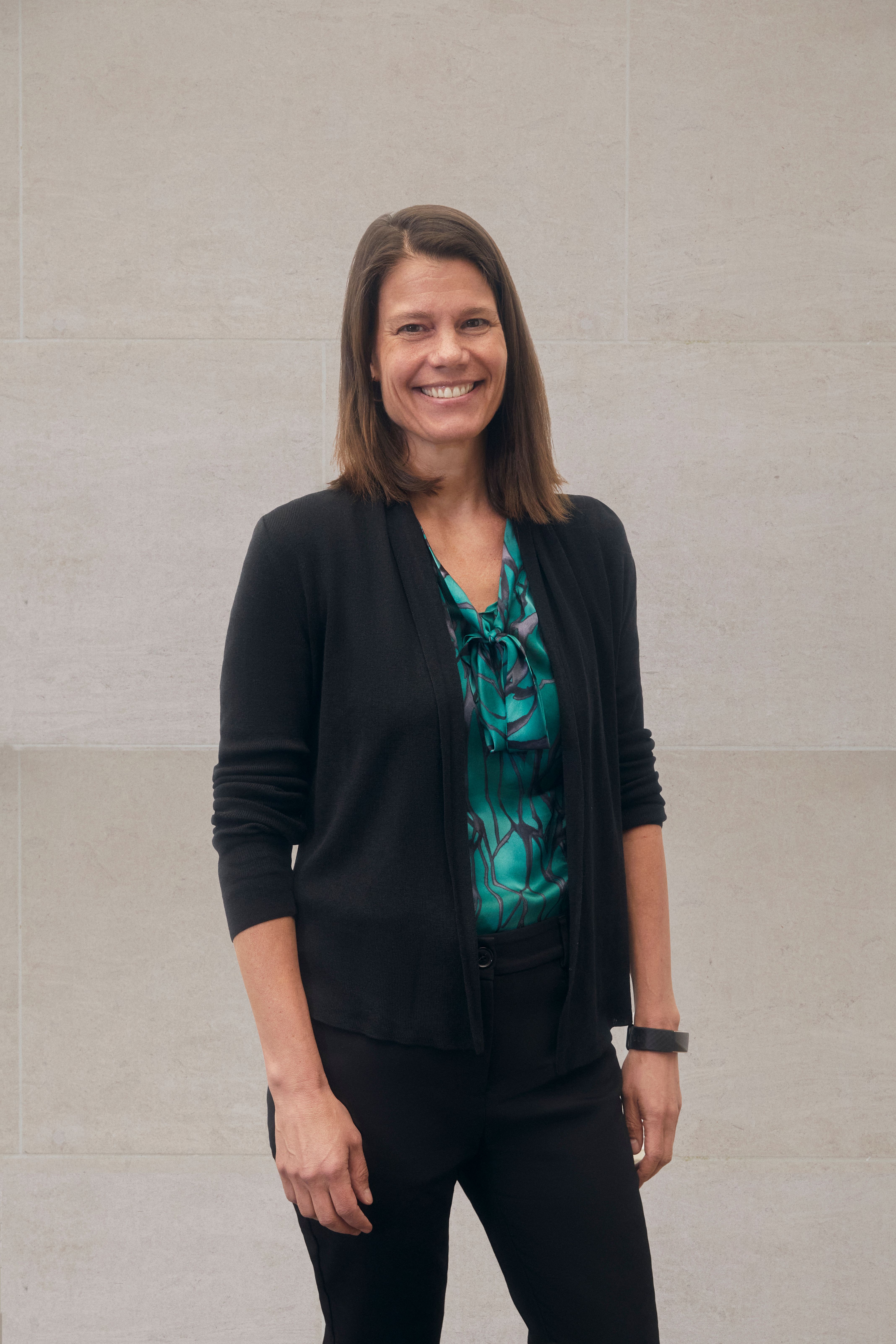 A color photograph of Lauren Meserve standing in front of a stone wall.