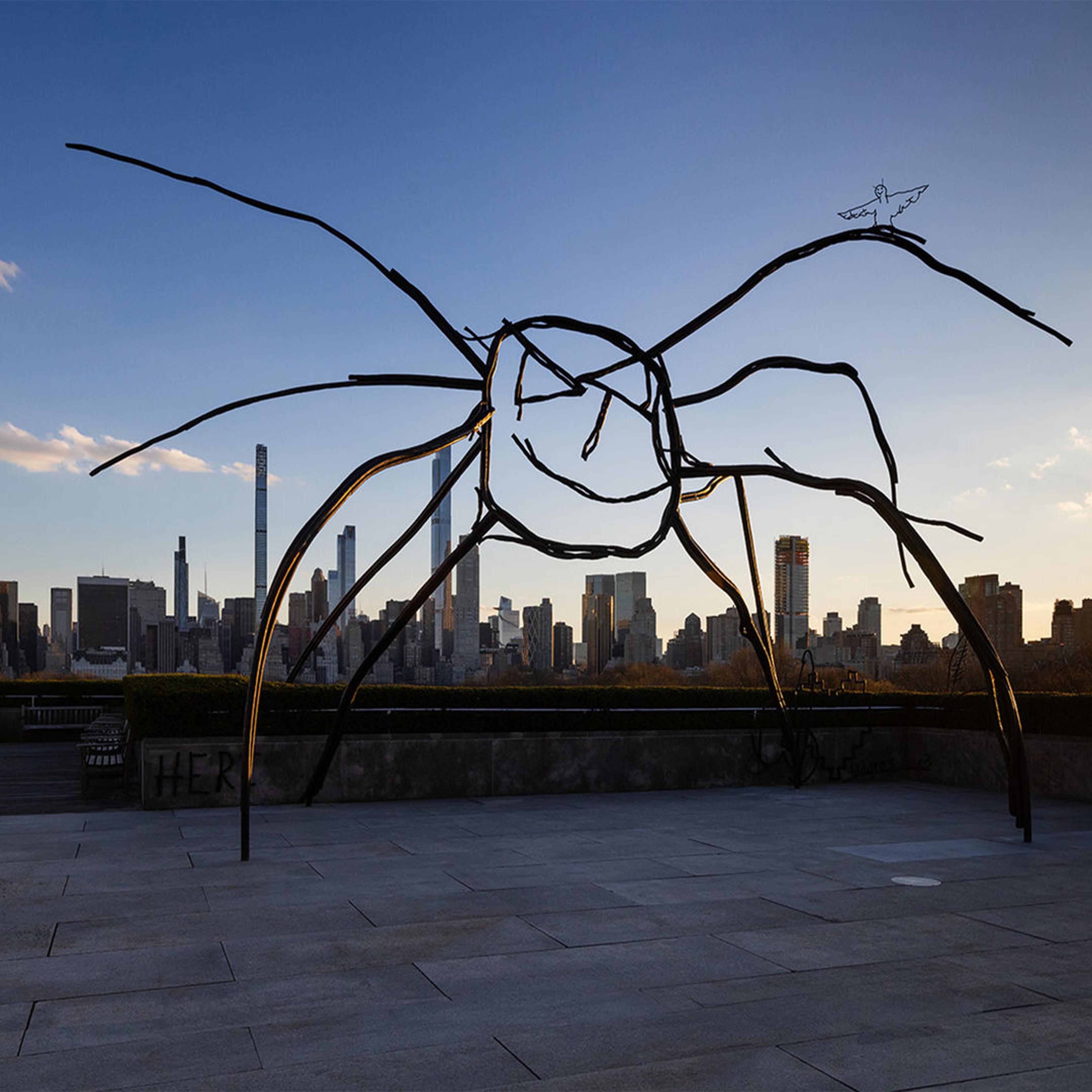 Metal scluped spider with the city skyline in the background.