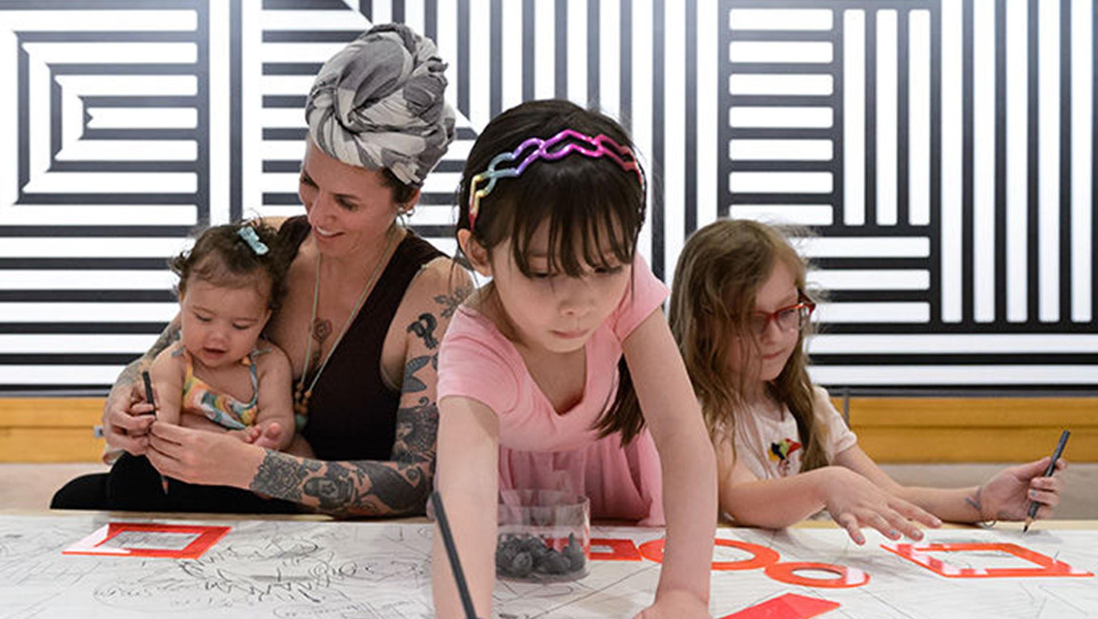 Children and a parent engaging in art making activities.
