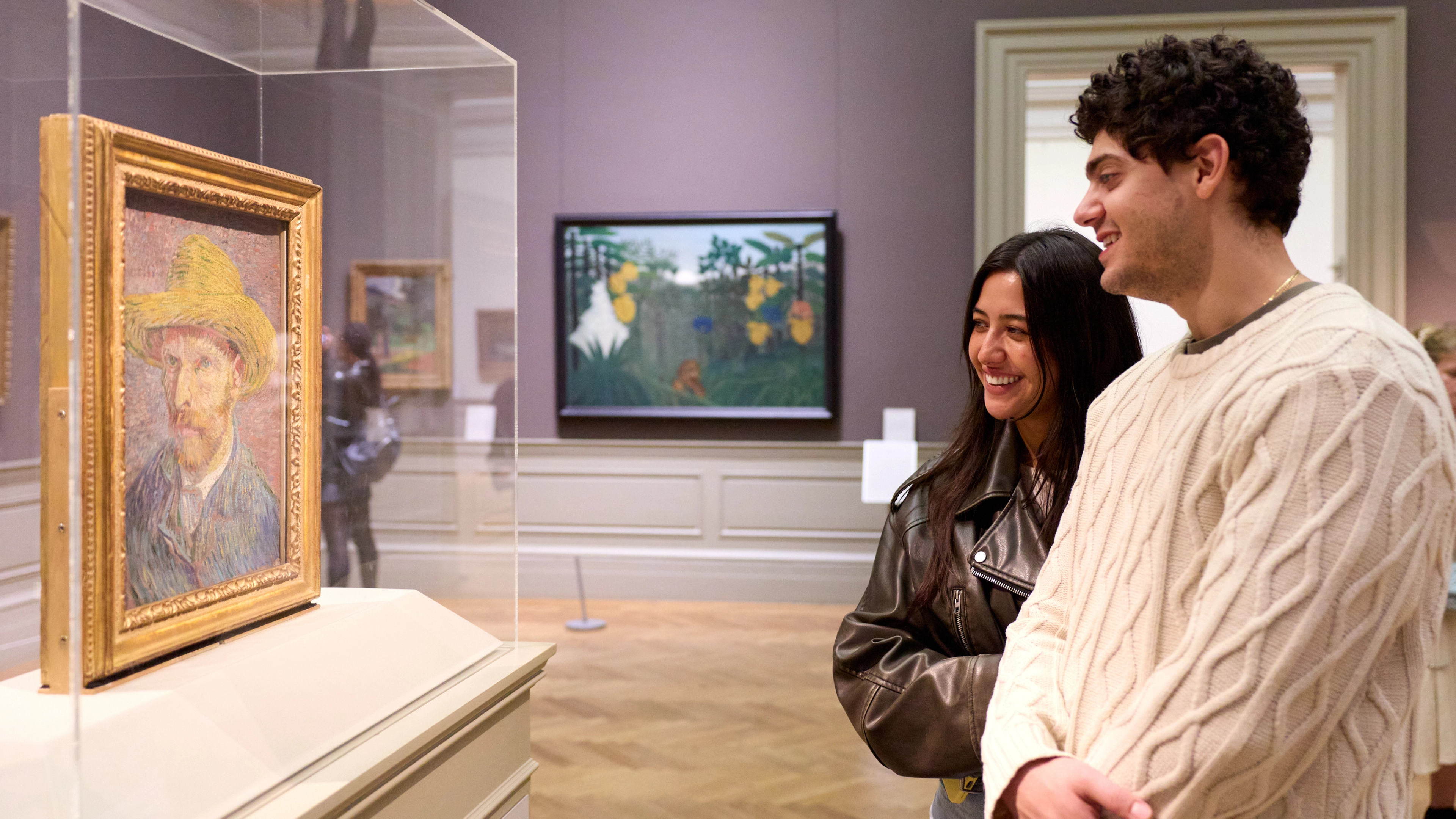 A couple looks at Vincent Van Gogh's "Self Portrait with a Straw Hat" 