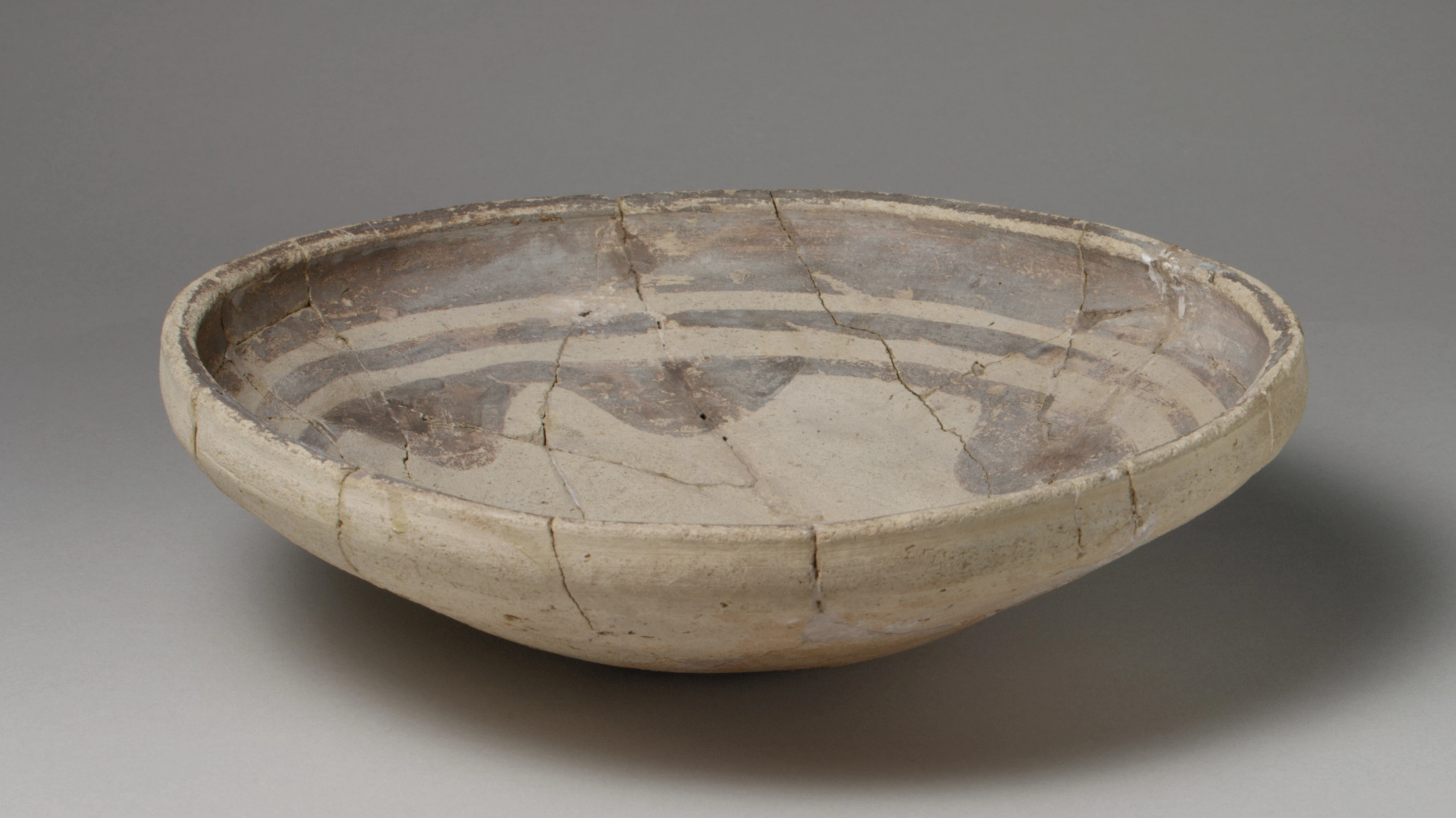 Ceramic dish decorated with a dark brownish paint in three concentric rings.