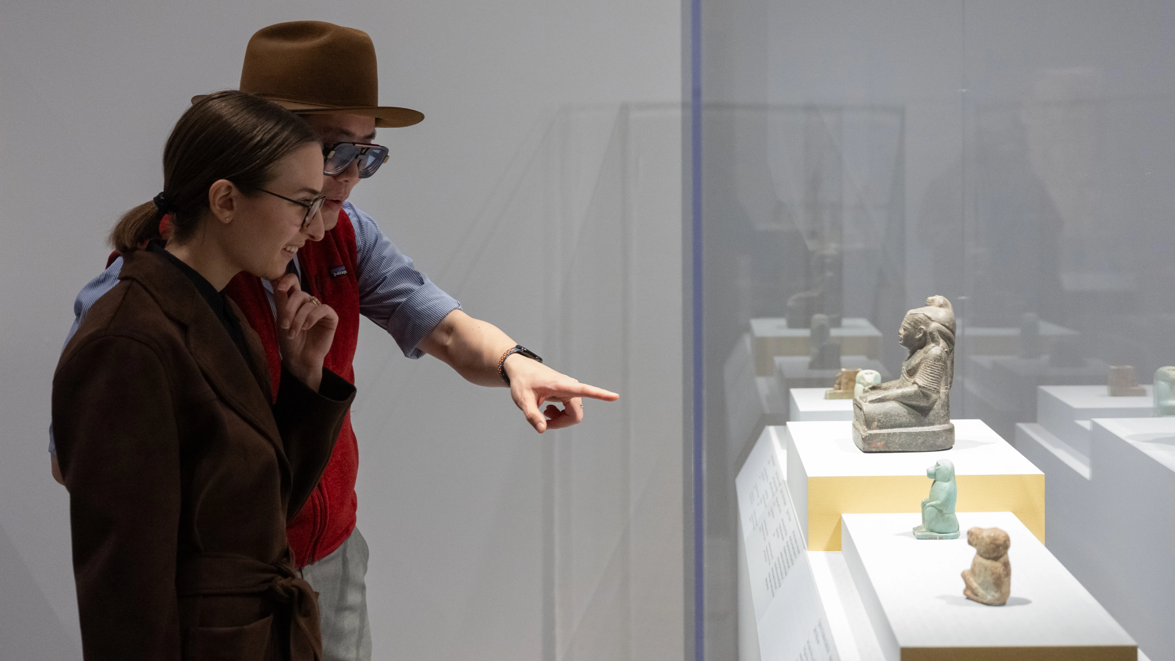 Two people pointing at sculptures.