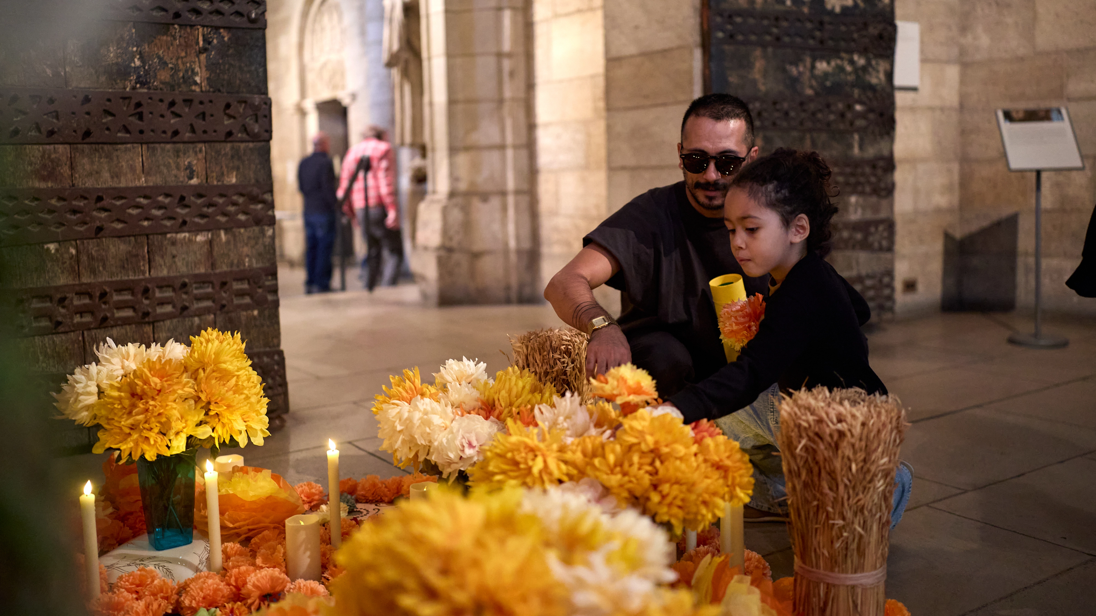 A family lighting candles at The Cloisters. 