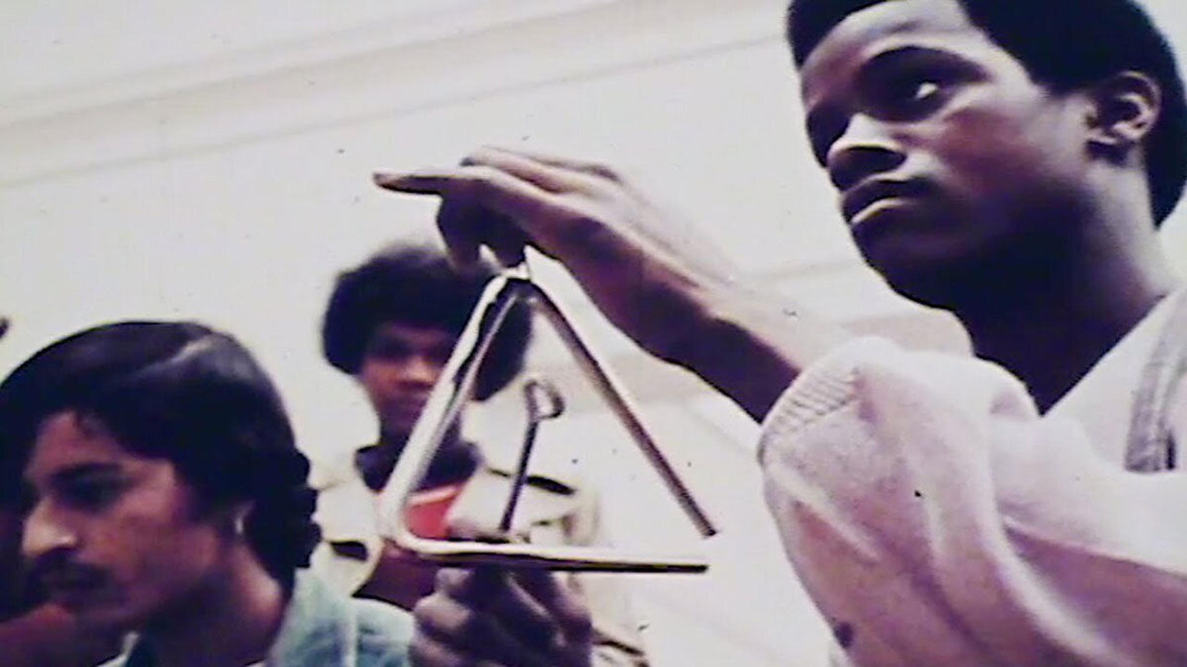 A man plays the triangle in a band