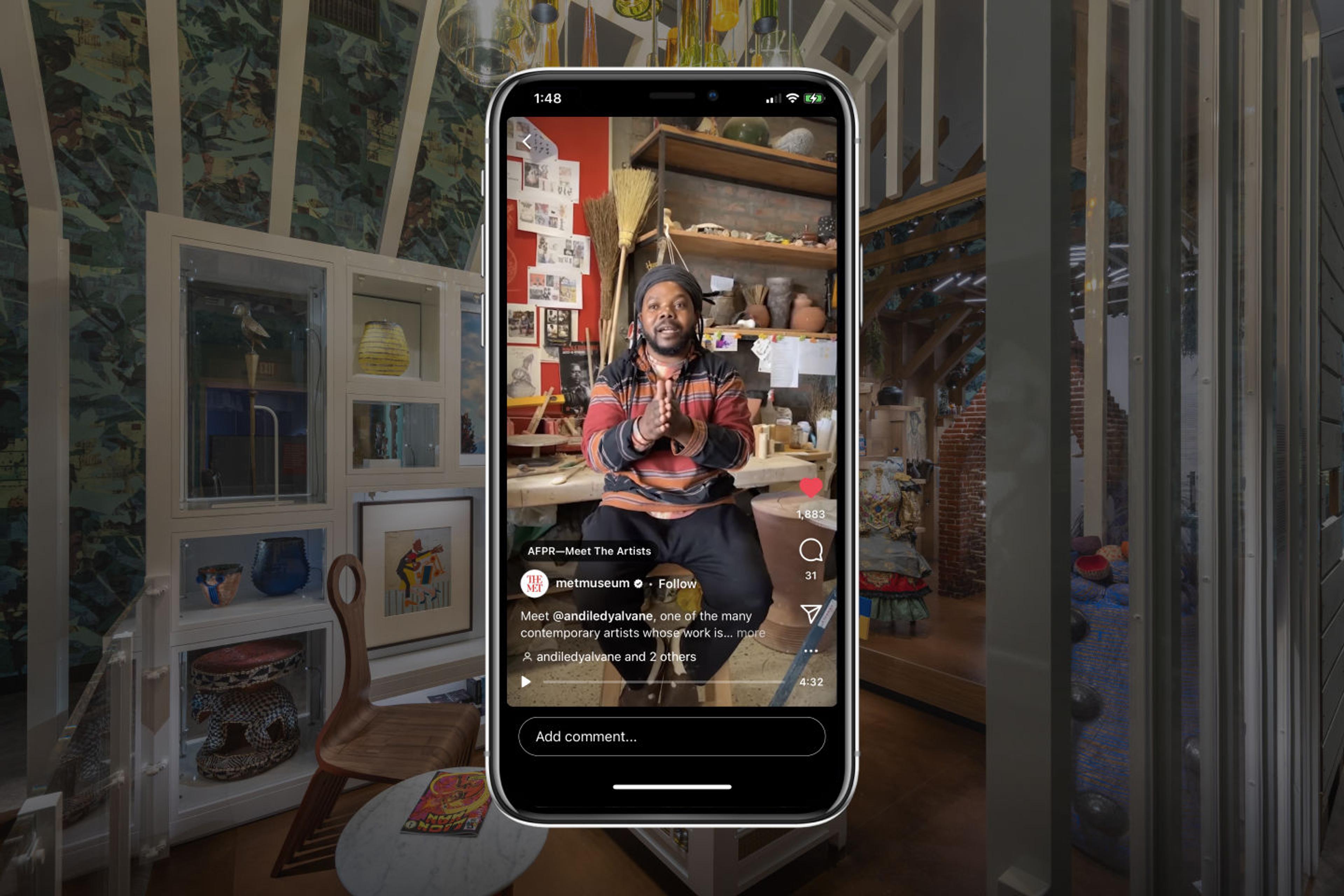 The artist Andile Dyalvane visible on a phone screen before a backdrop from the Afrotuturist period room at The Met.