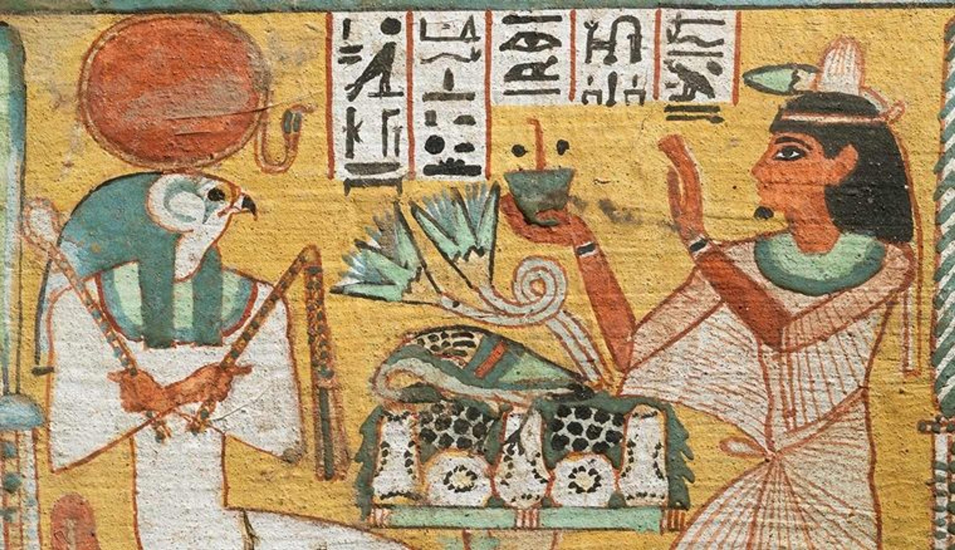 An ancient Egyptian painting of a falcon-headed god being approached by a man holding a vessel