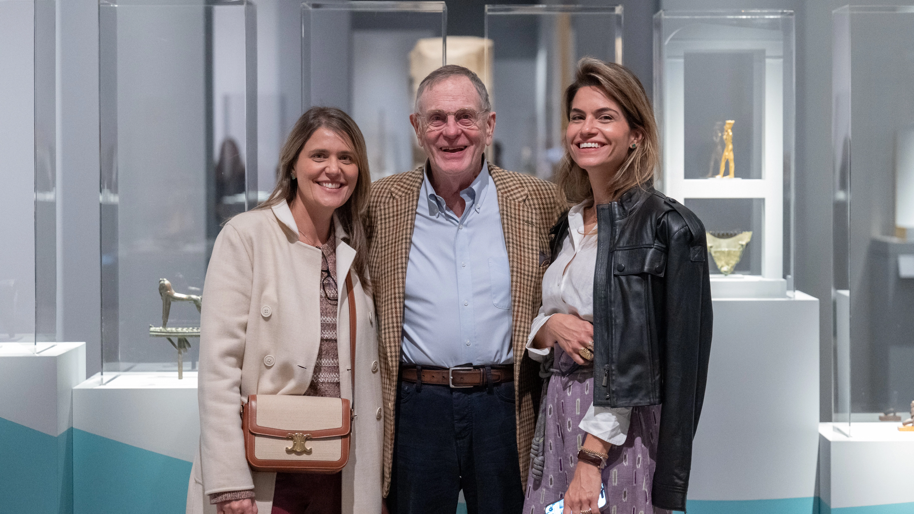 Three people side by side smiling.