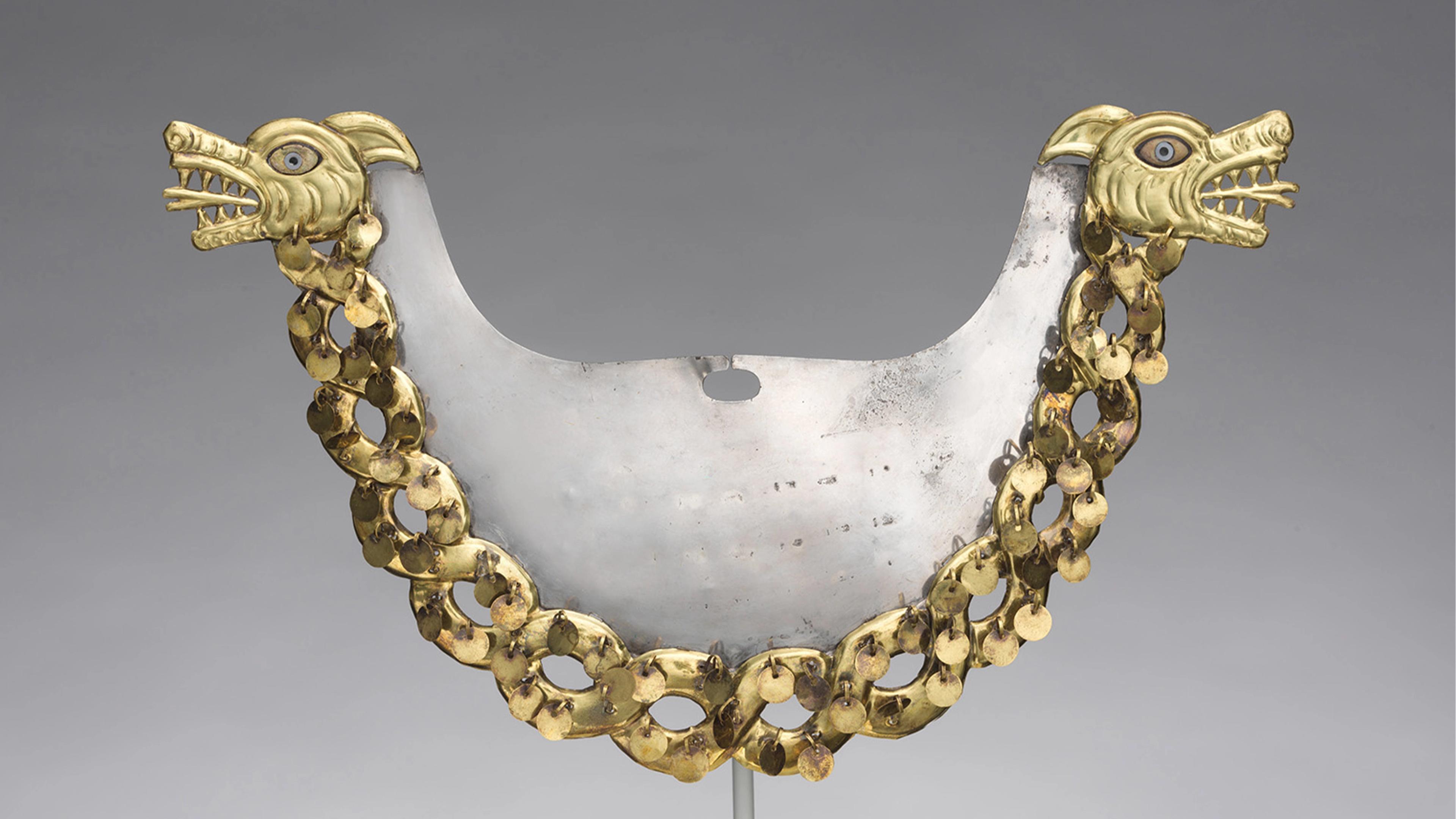 An ornate metal breastplate with two dragon heads, detailed with gold and blue accents. Connected by a chain of gold links