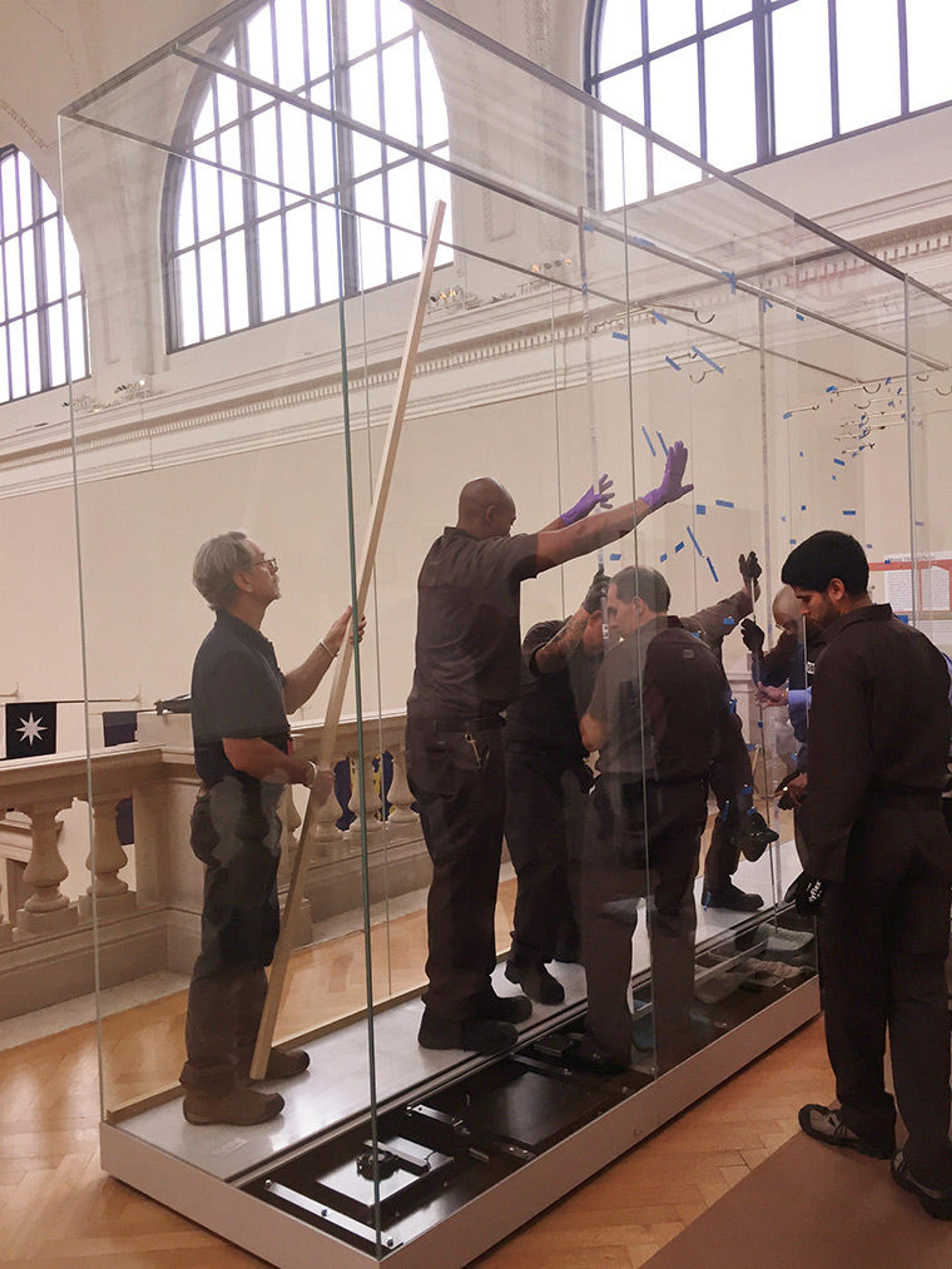 The riggers installing the acrylic panels in the case