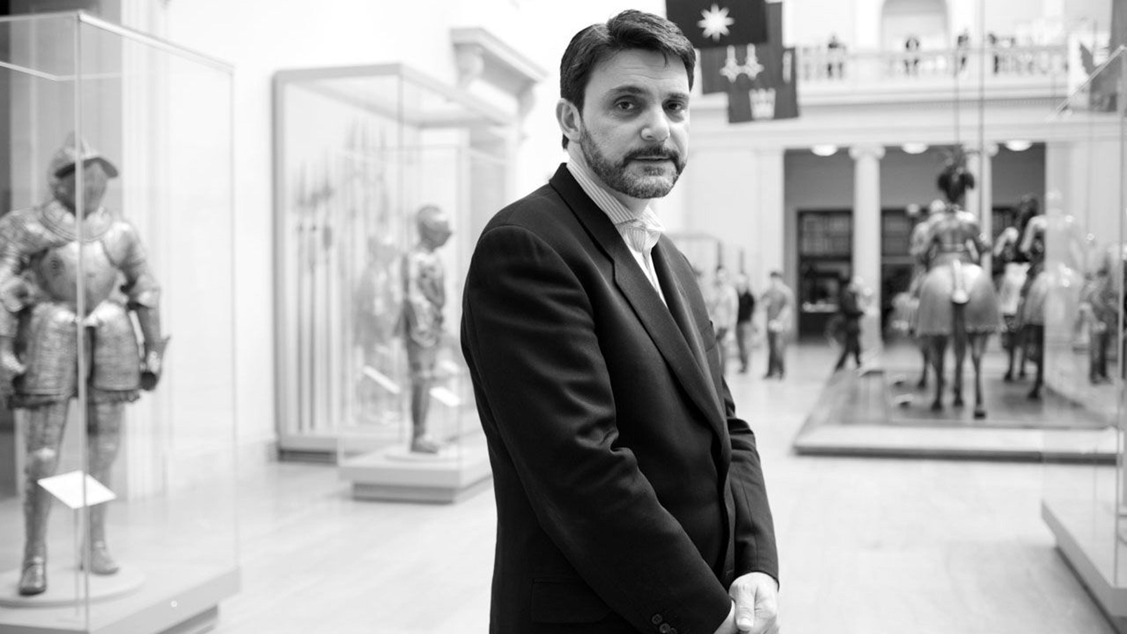 Black and white photograph of Peter Antony standing in a gallery at The Met
