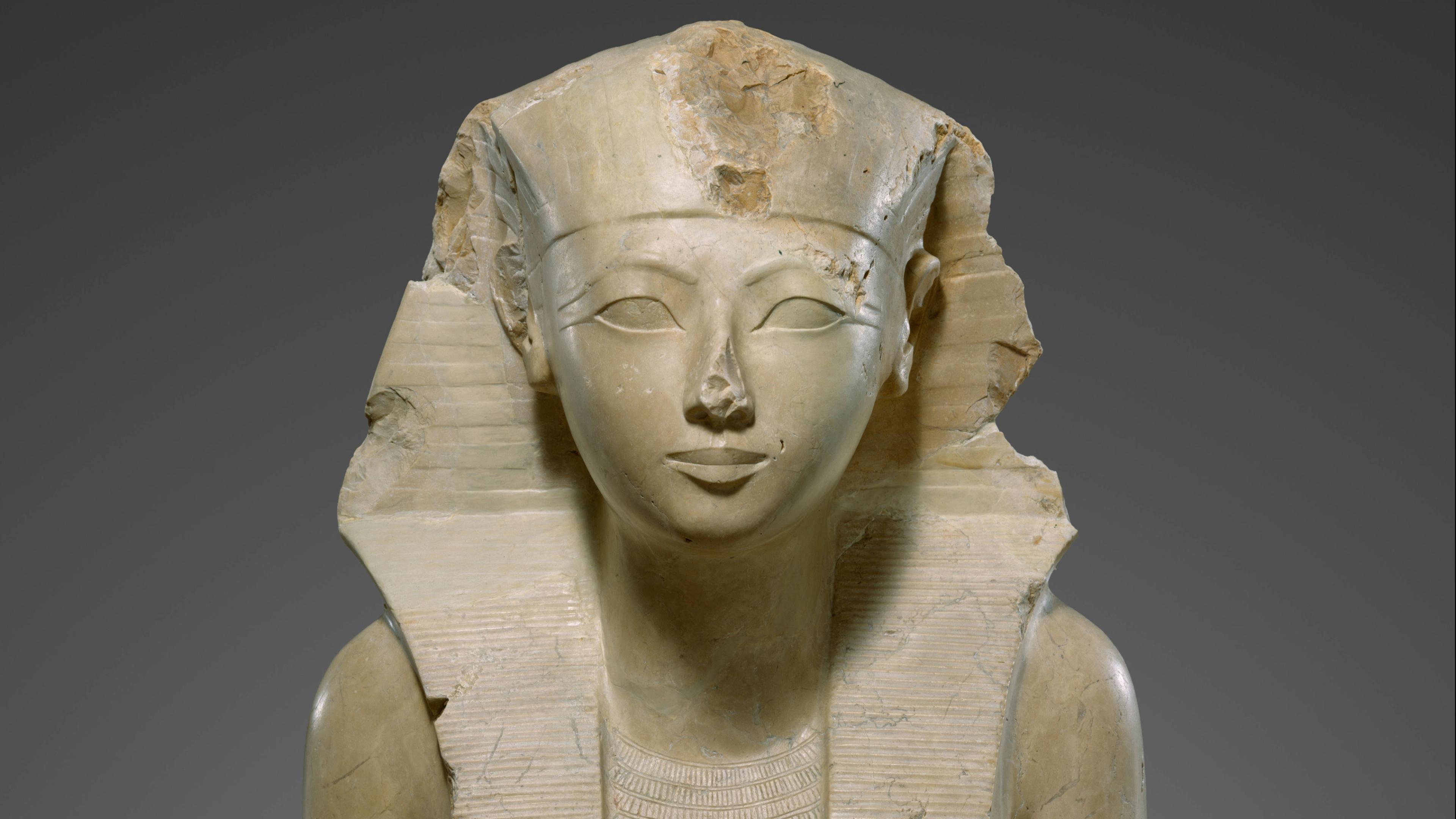 Marble statue of an ancient Egyptian pharaoh wearing a headdress.