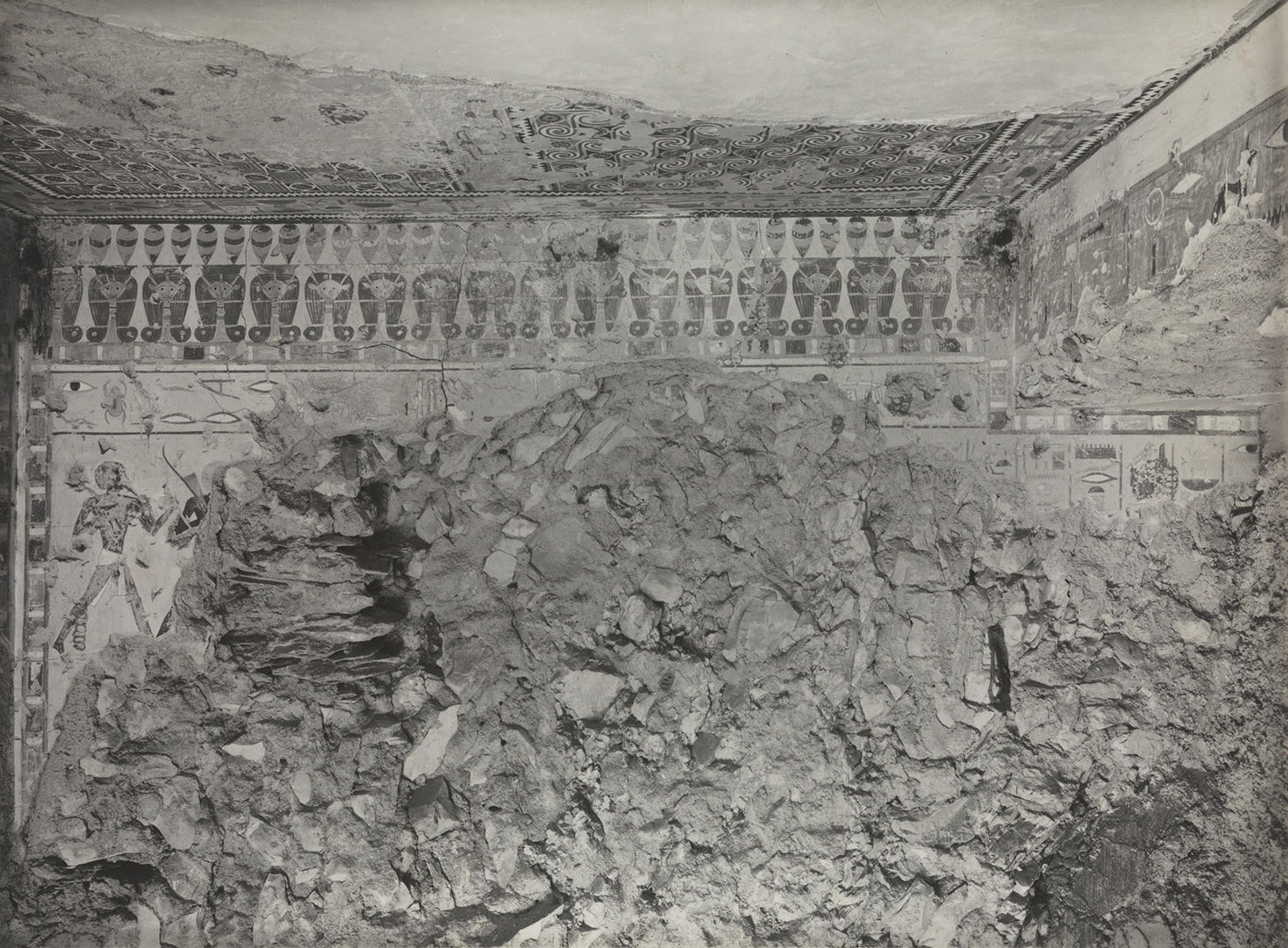 Black and white view into a tomb, with one wall mostly desroyed.