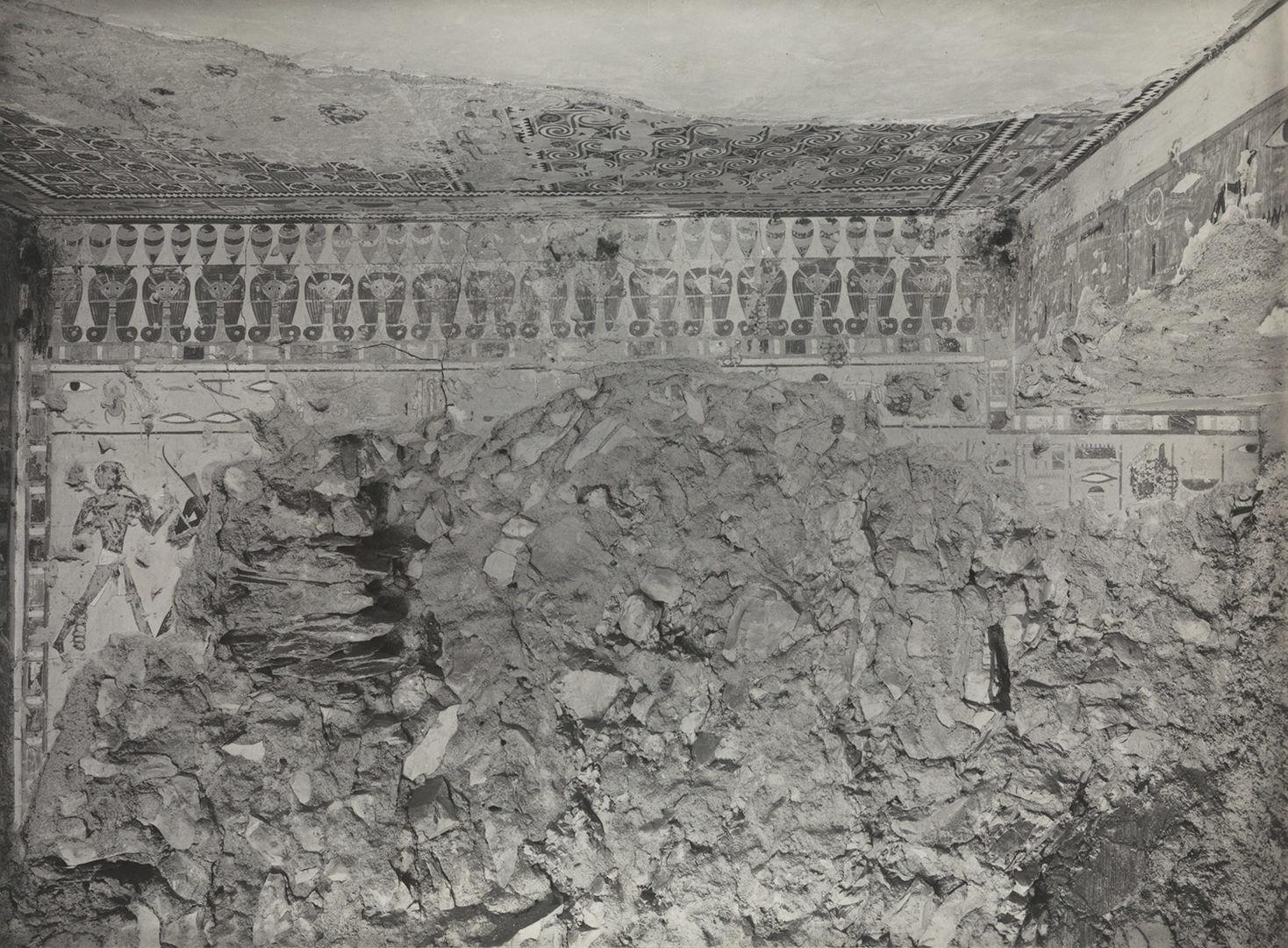 Black and white view into a tomb, with one wall mostly desroyed.