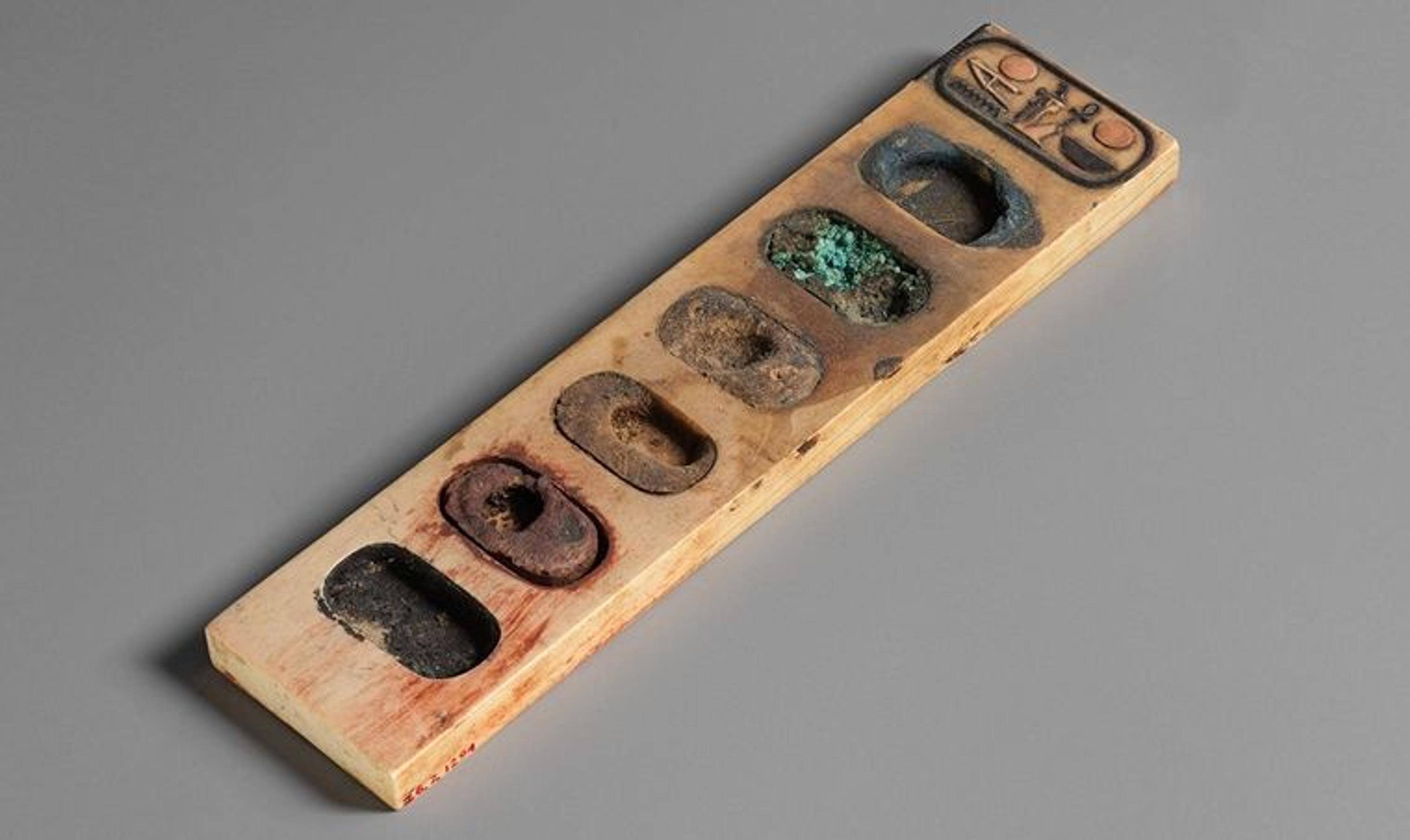 An ancient Egyptian painter's palette, with dried cakes of paint in each compartment.