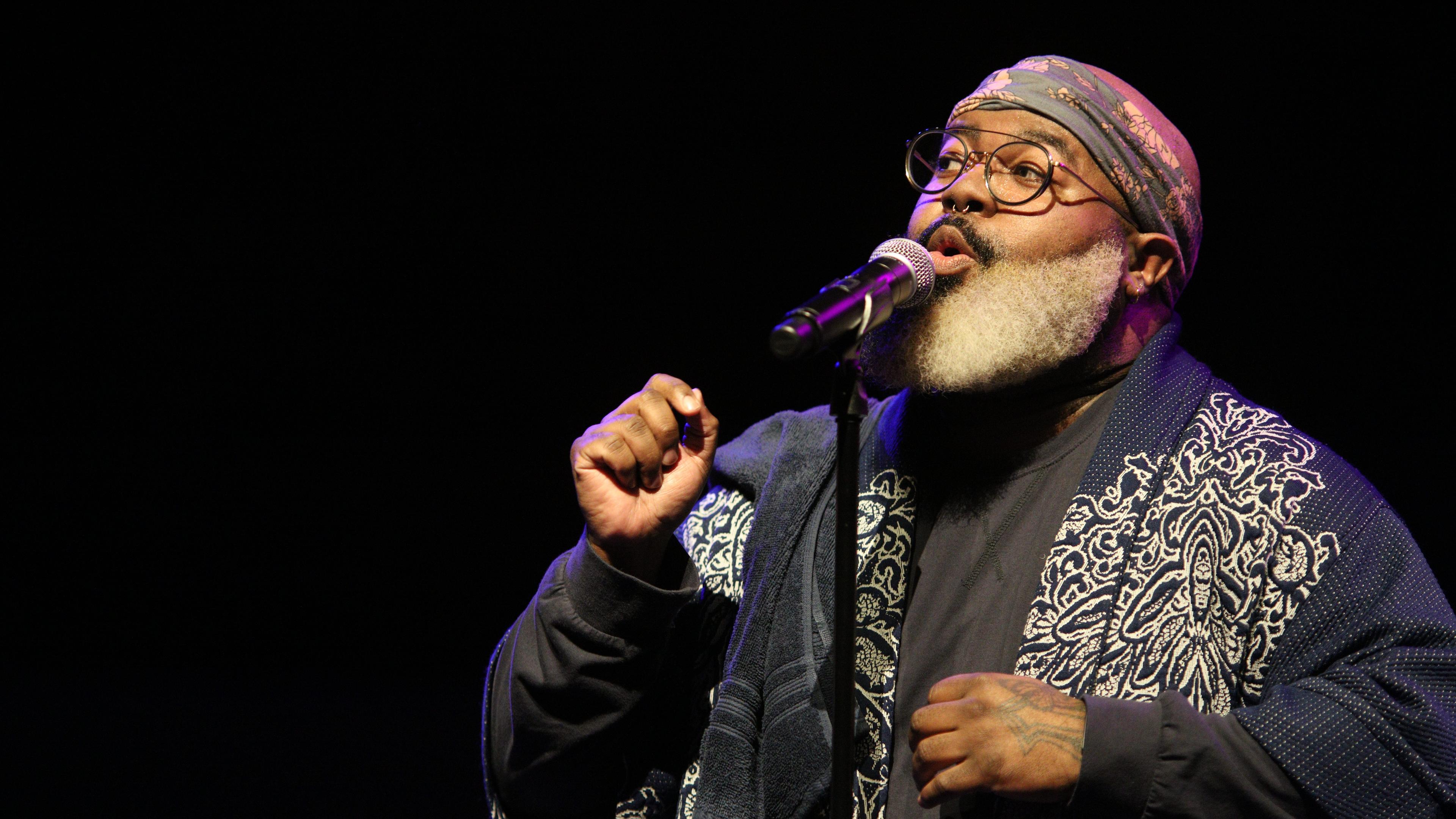 Image of a man singing in front of a microphone.