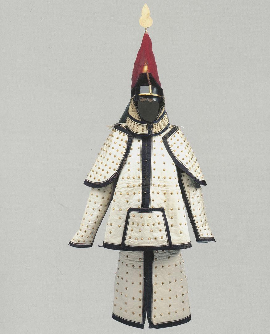 A padded suit of armor with a red hat and lined in black. The armor is decorative and against a gray background.