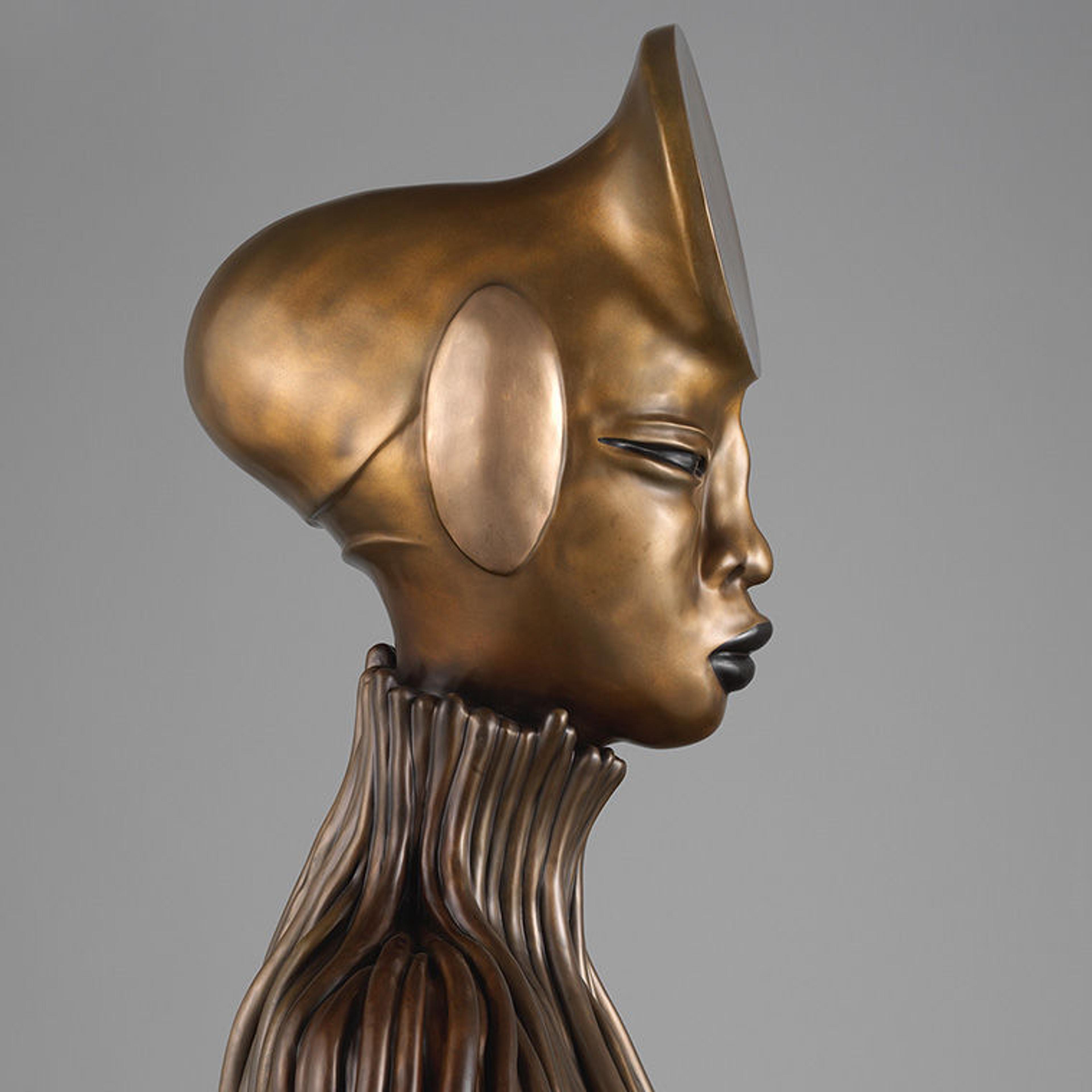 Detail of a patinated bronze sculpture of a seated woman with coils and mirrored surfaces