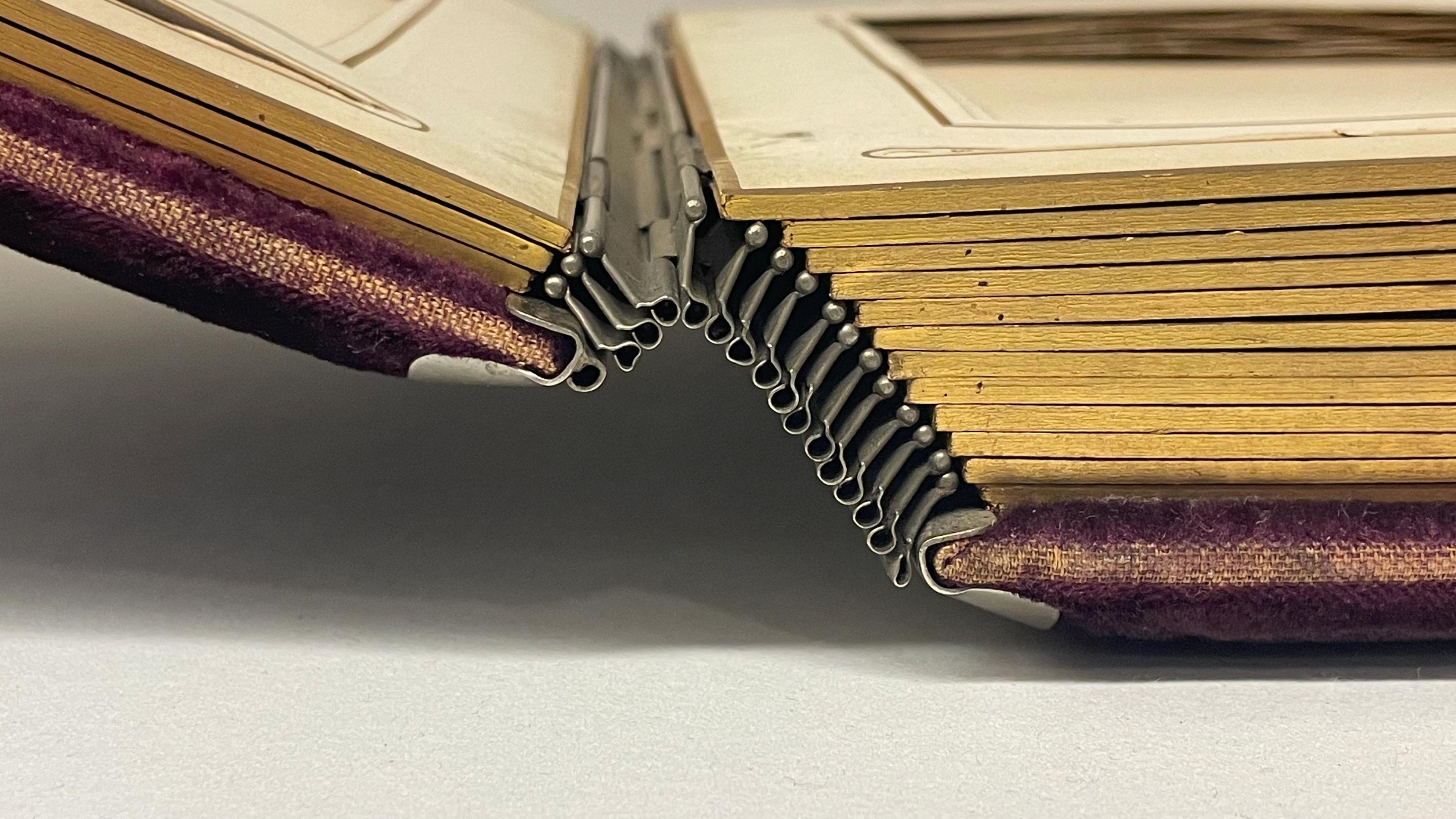 Side view of a metal back photo book hinge.