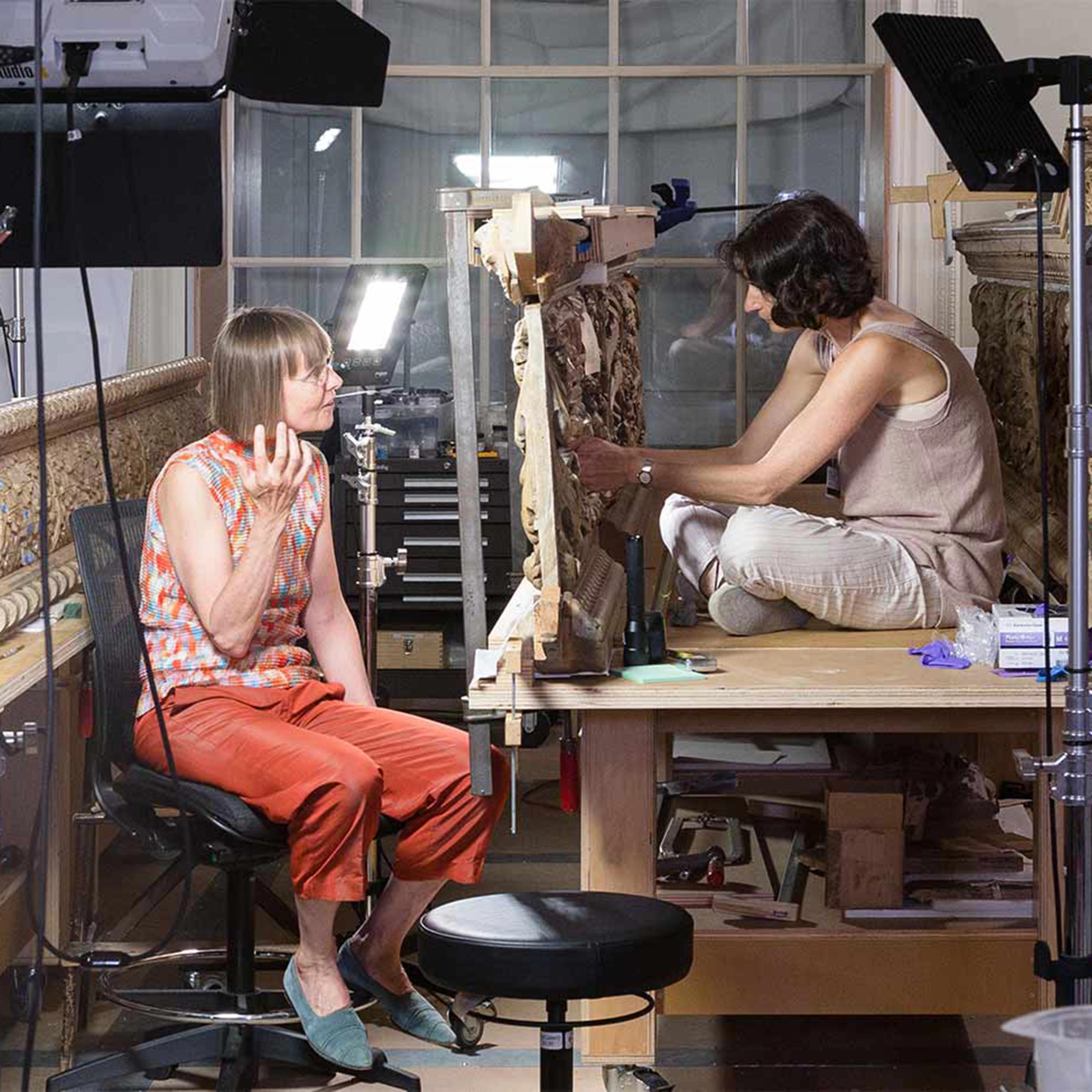 Two conservators in their lab staining wood paneling for the British Galleries