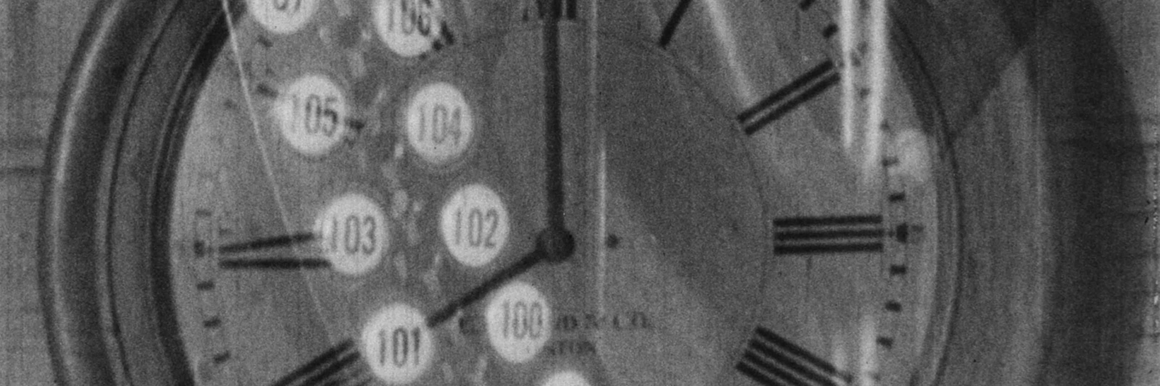 A black-and-white still from the 1928 film Behind the Scenes: The Working Side of the Museum, which depicts the superimposed image of an old-fashioned time-card machine over the face of a wall clock