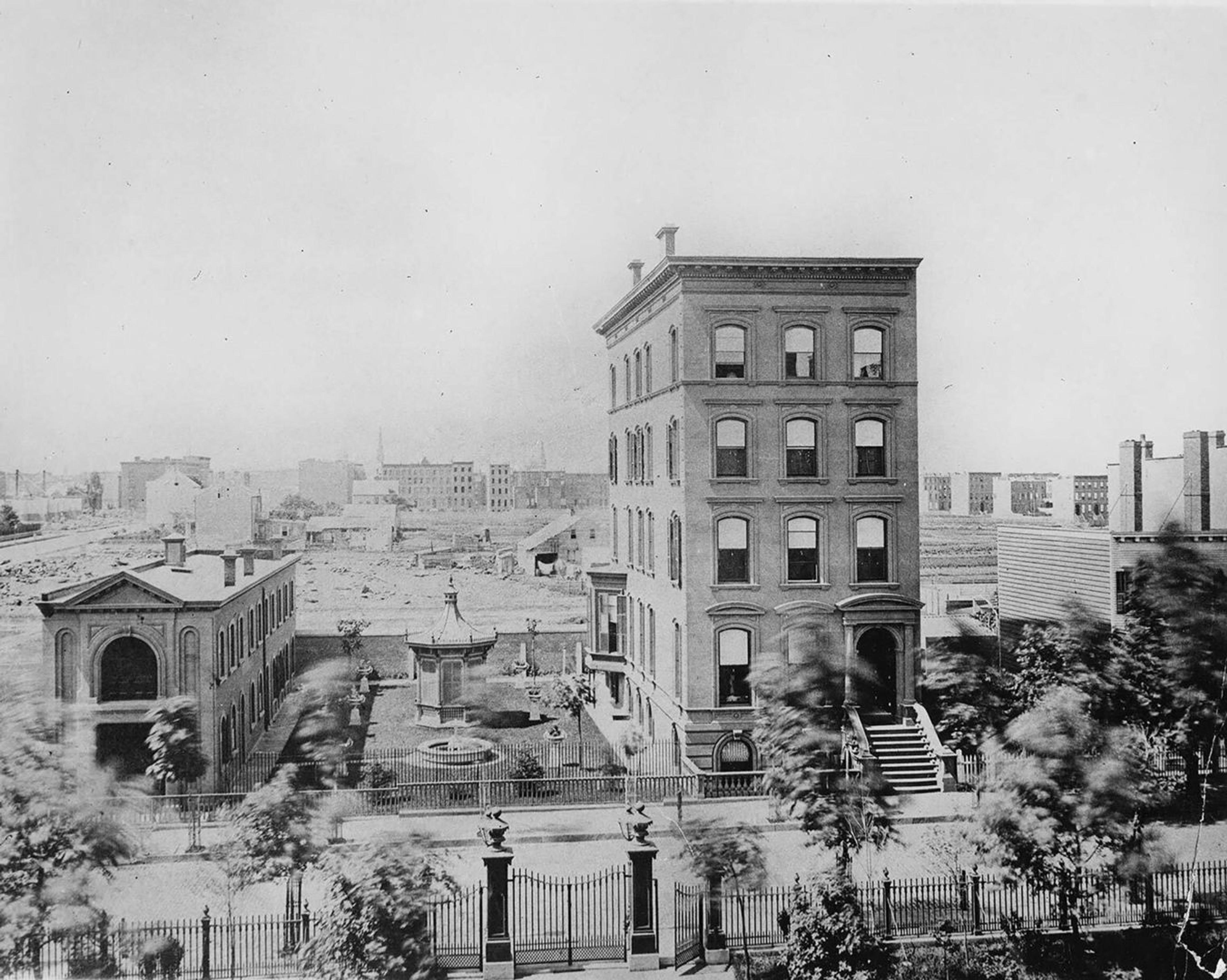An old photo of a five-story building on 54th St towering over nearby structures