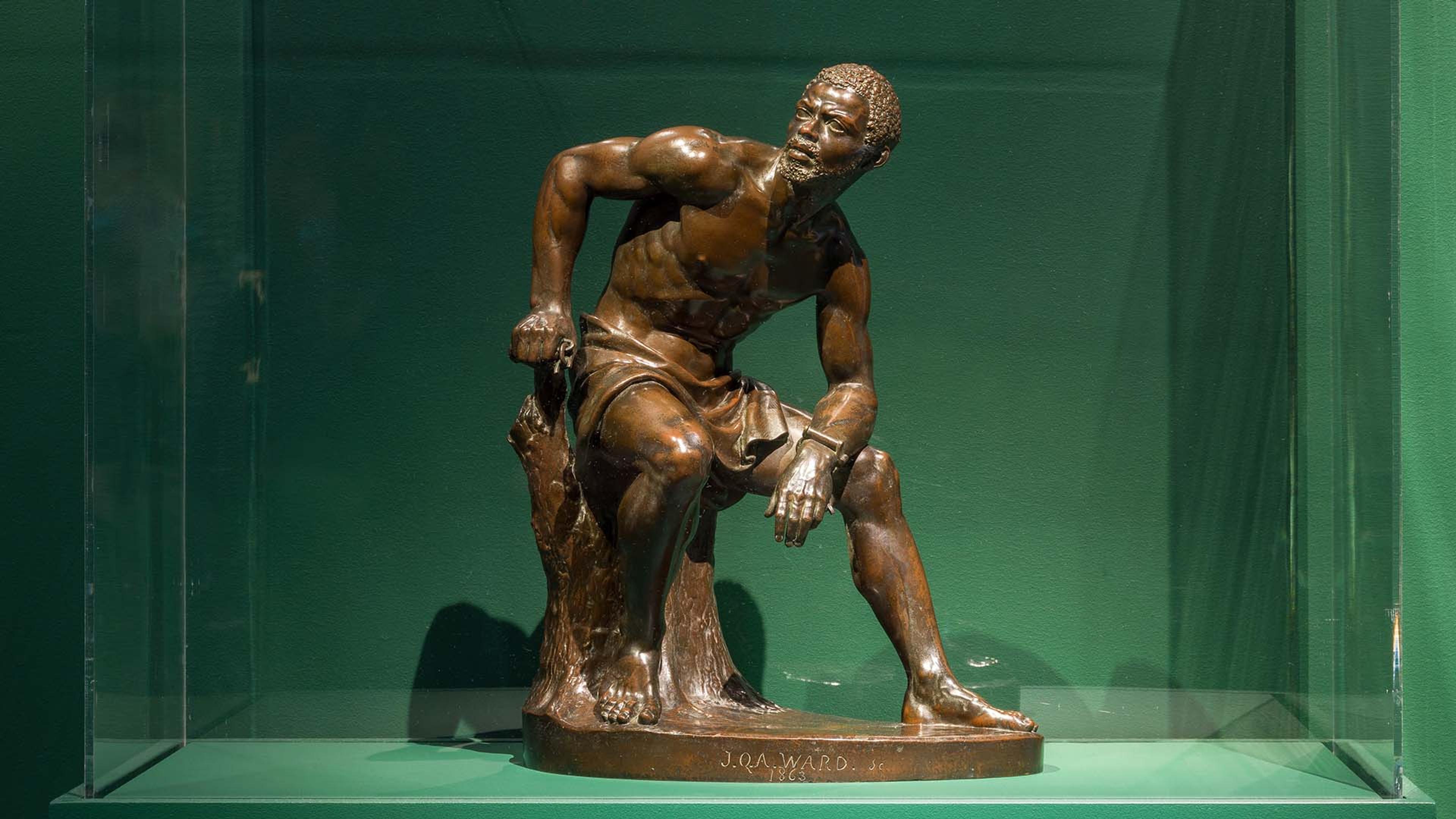 Sculpture of a man against a green backdrop