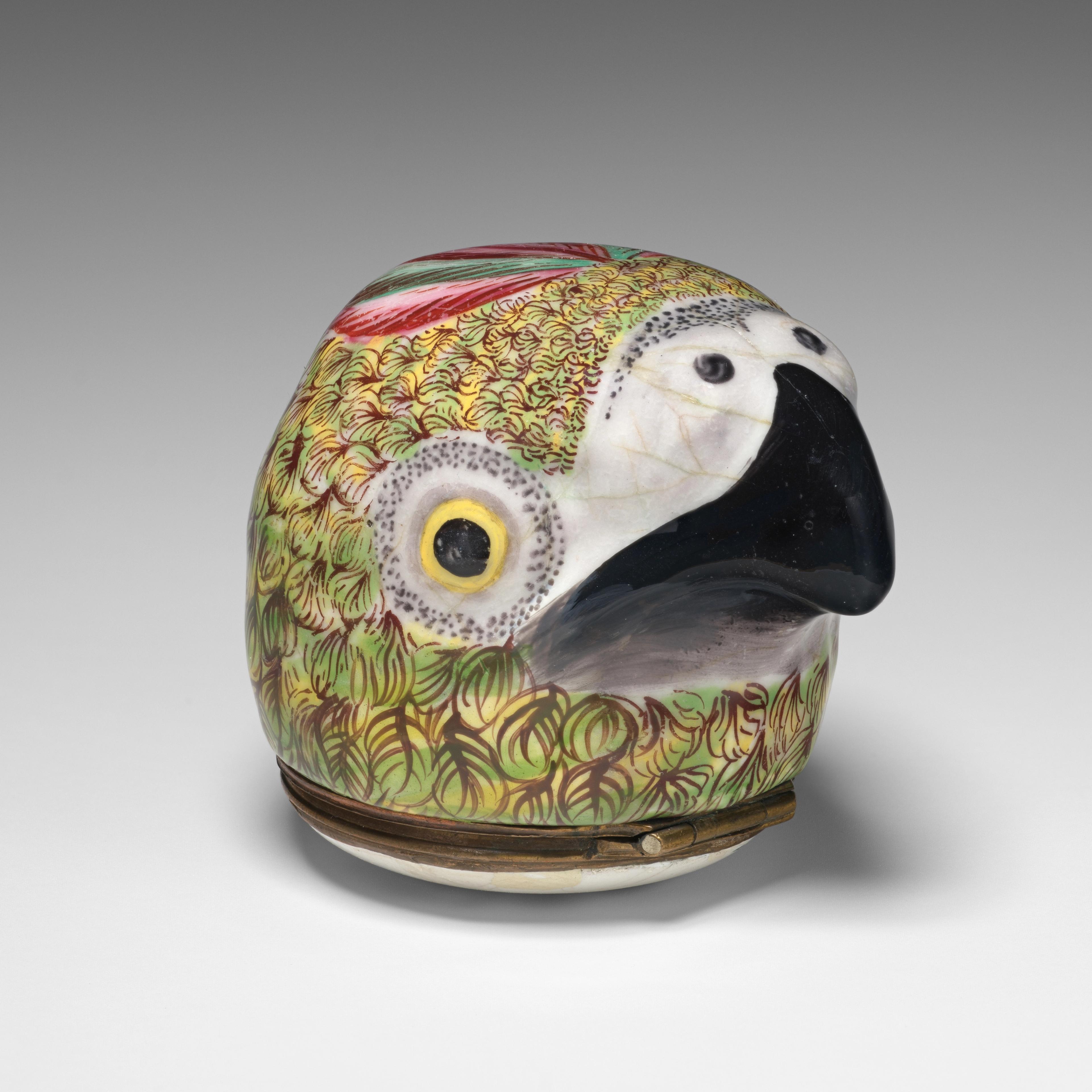 A green, yellow, and pink parrot's head, with a hinge at the base of its neck.