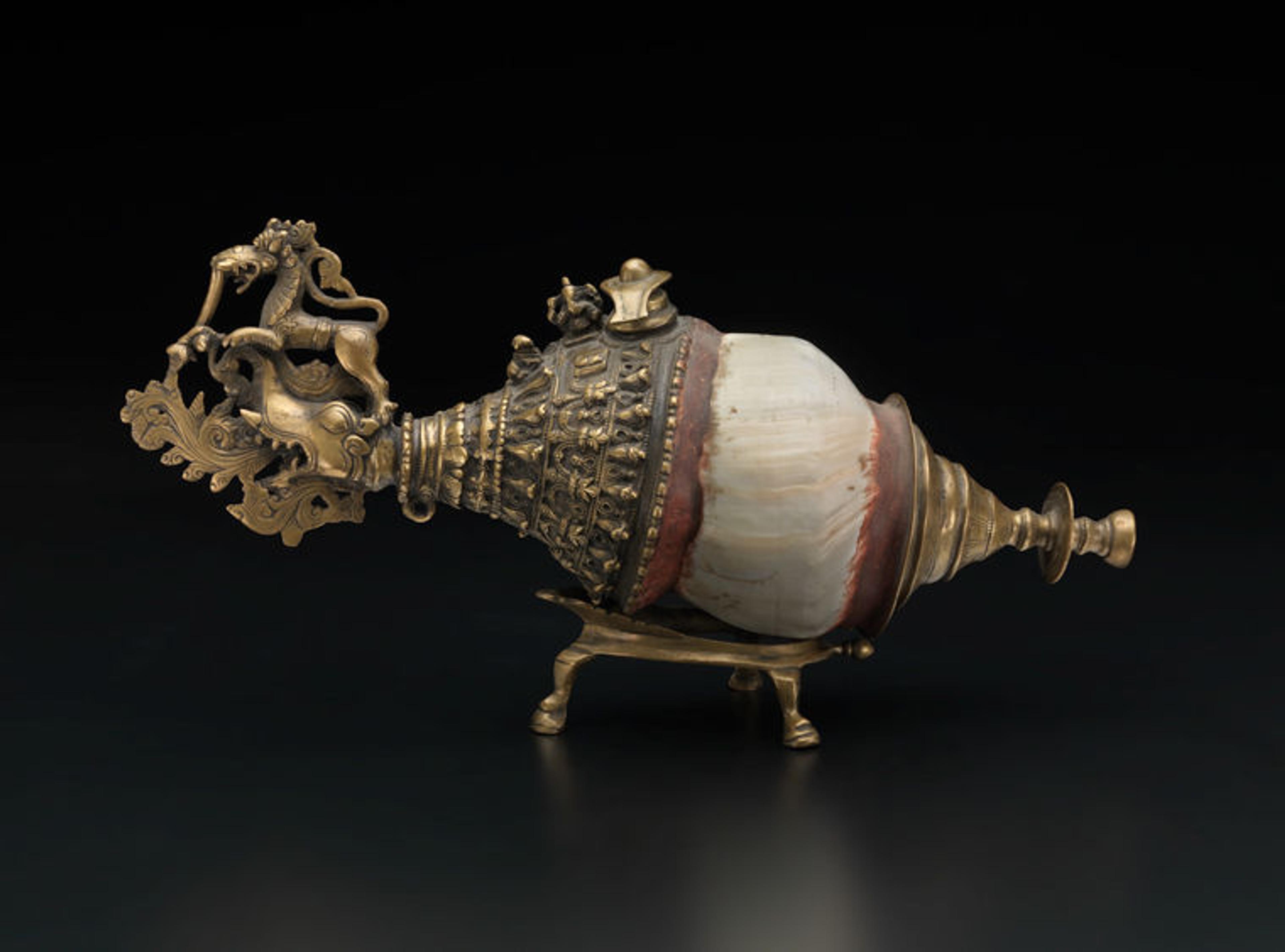 An elaborate Indian sankh (conch trumpet) featuring brass work and placed on a brass stand