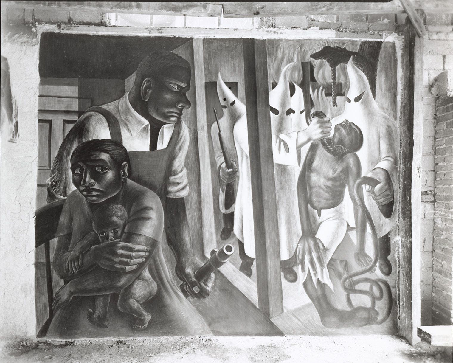  A Black man with a gun protects a mother and child on the left while hooded figures menace another man on the right.