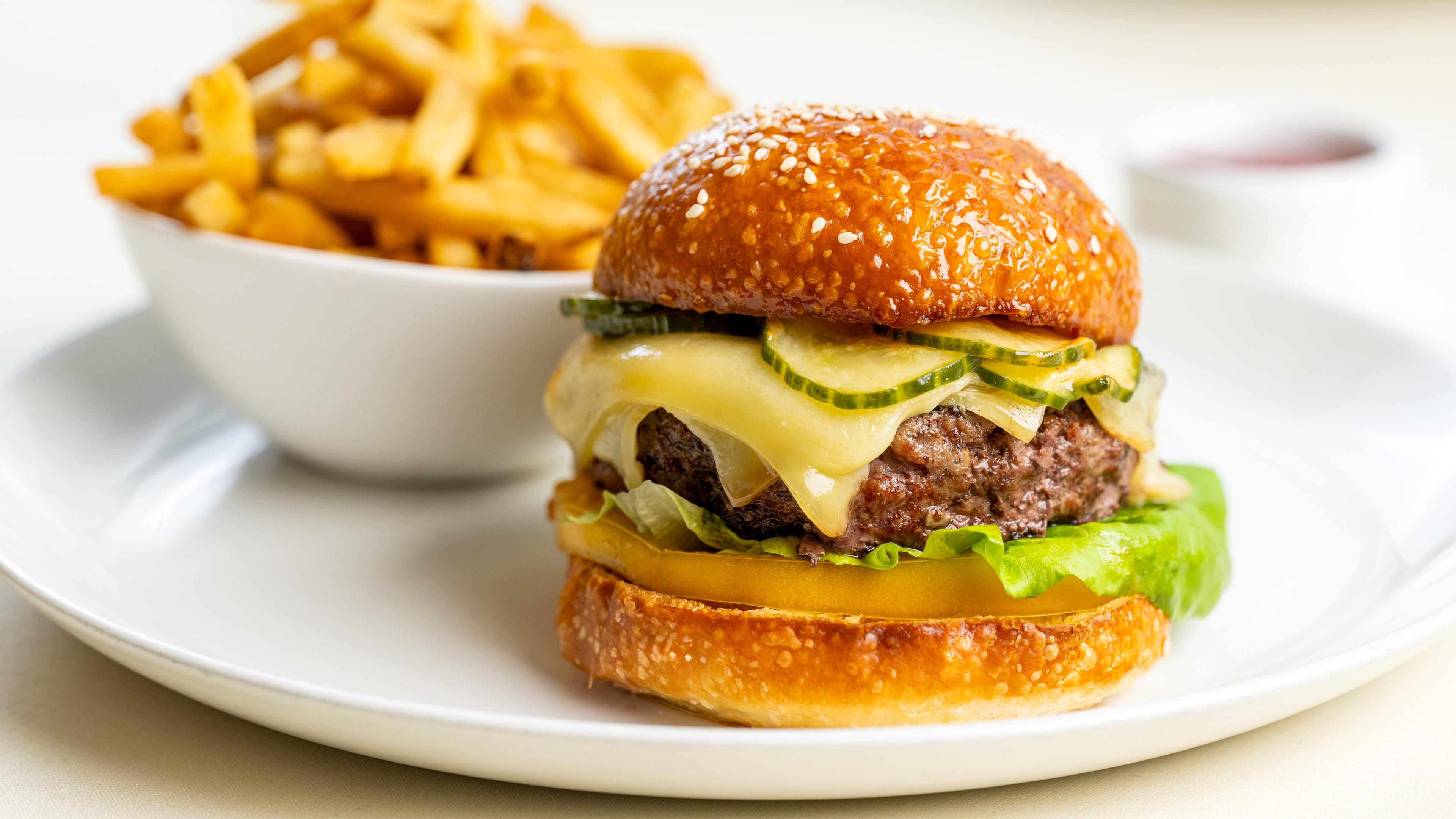 A plate of food, cheese burger with french fries