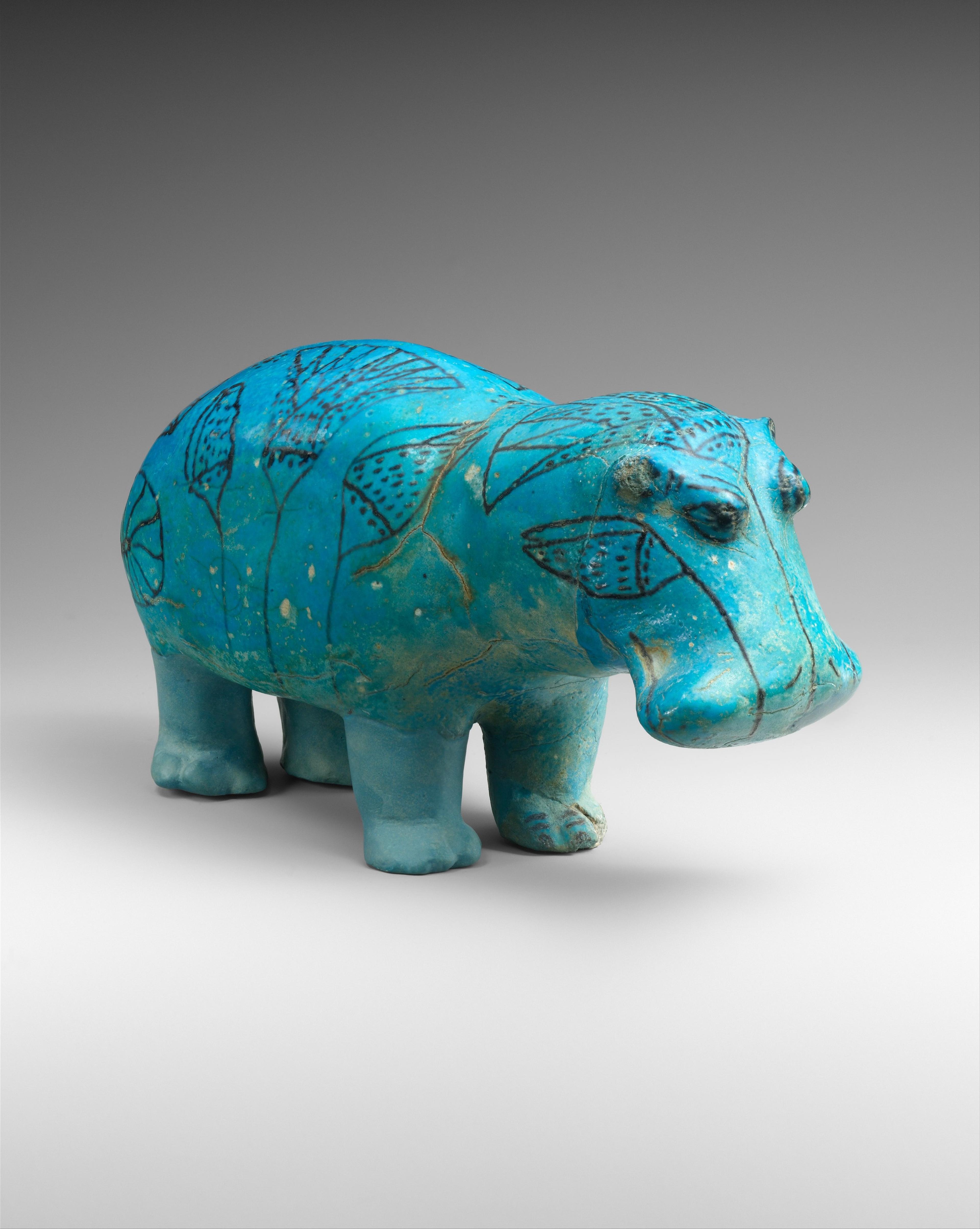 A blue hippo with lotus flower decorations painted across its surface.