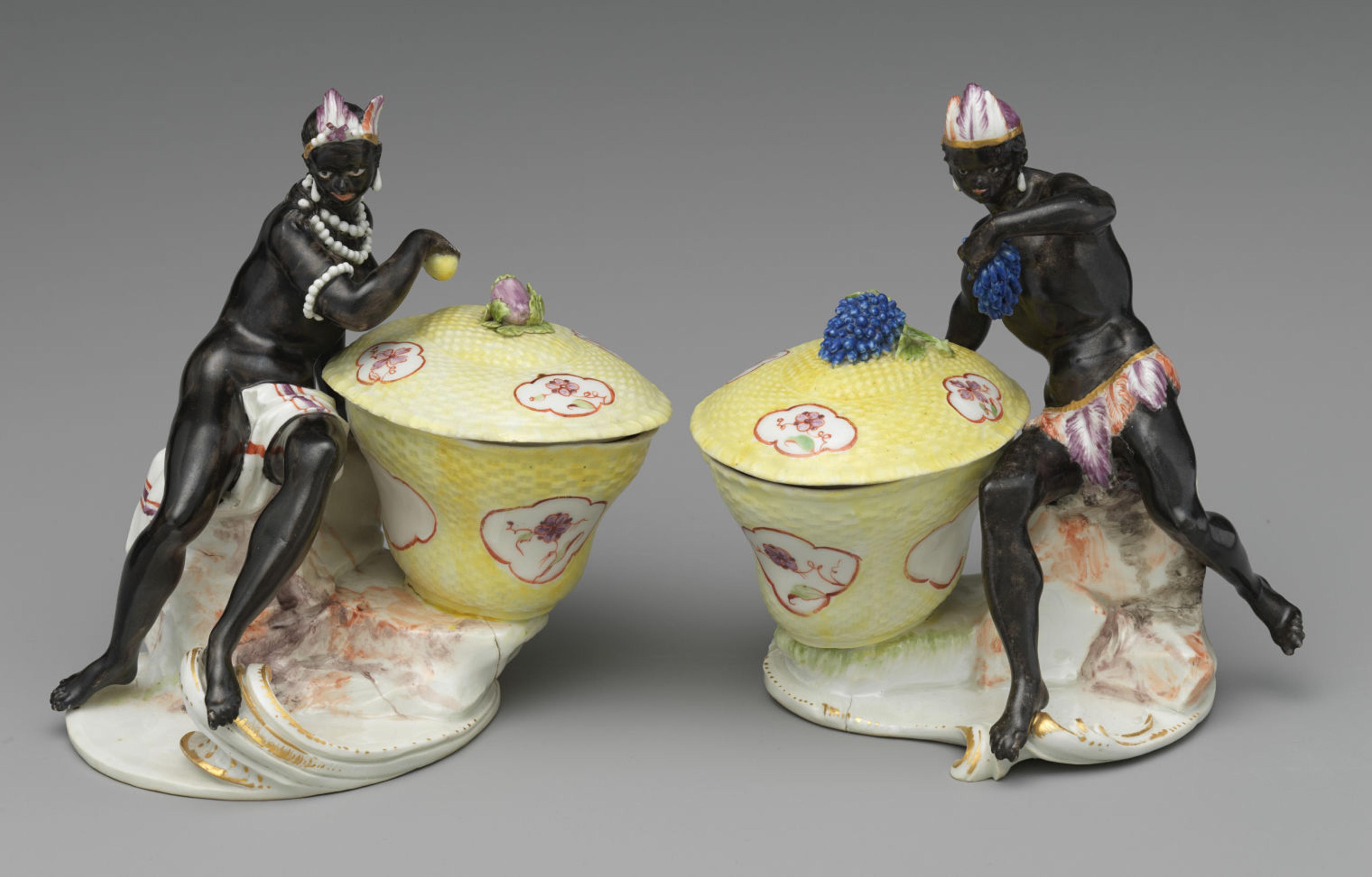 A pair of black men with feathers decorating their heads and body next to a cup covered with a lid